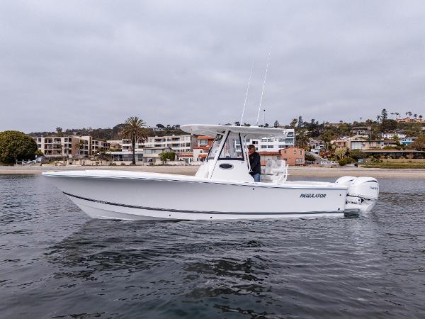 2025 Regulator 28 boat on calm water near coastal town.