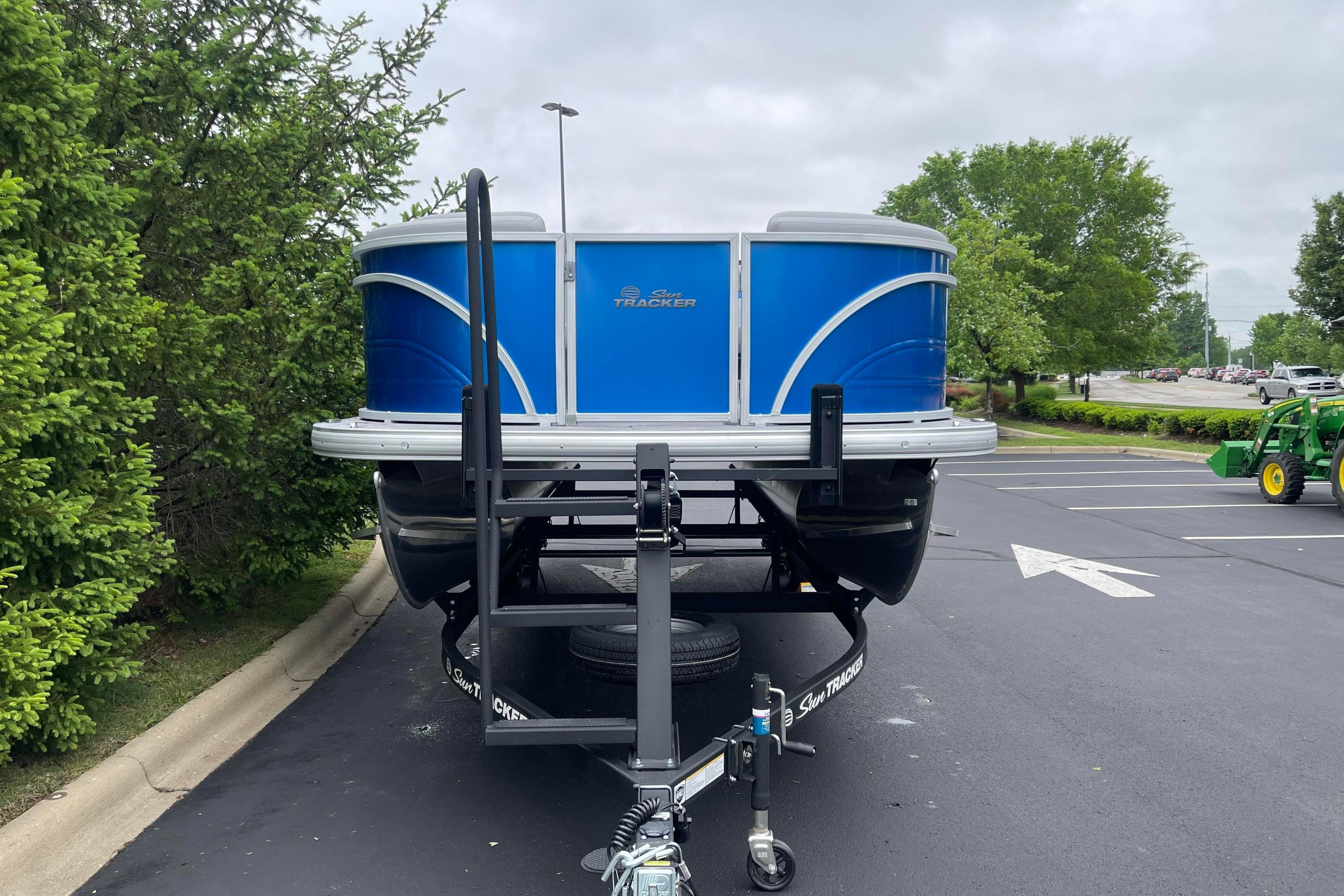 2026 Sun Tracker Party Barge 22 RF DLX on trailer in parking lot.