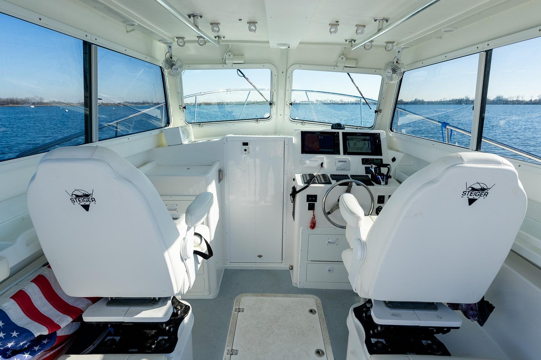 2024 Steiger Craft 31 Fisherman boat interior with steering console and seating.