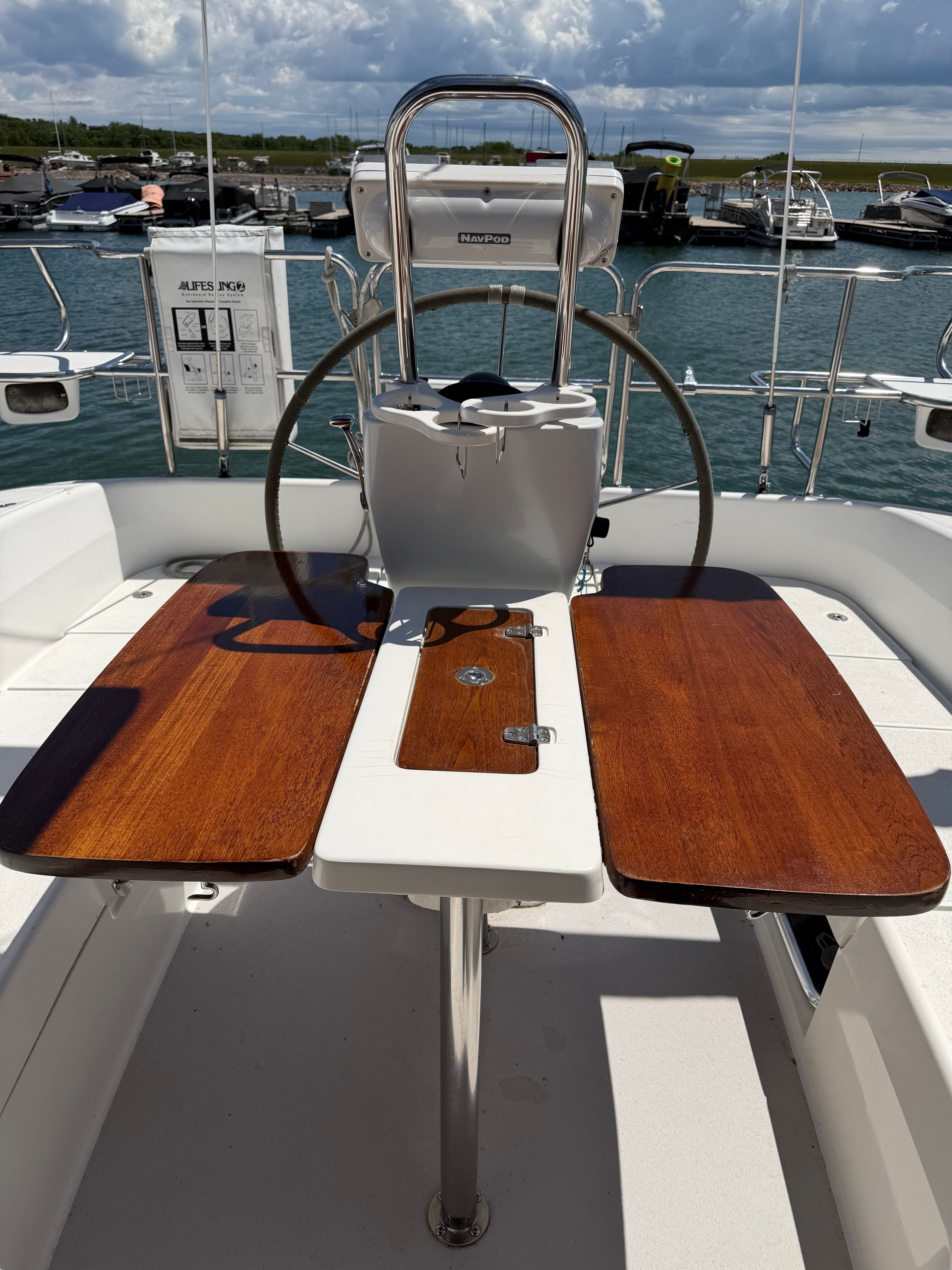 The cockpit of a 2004 Catalina 350 with a wooden table and steering wheel.