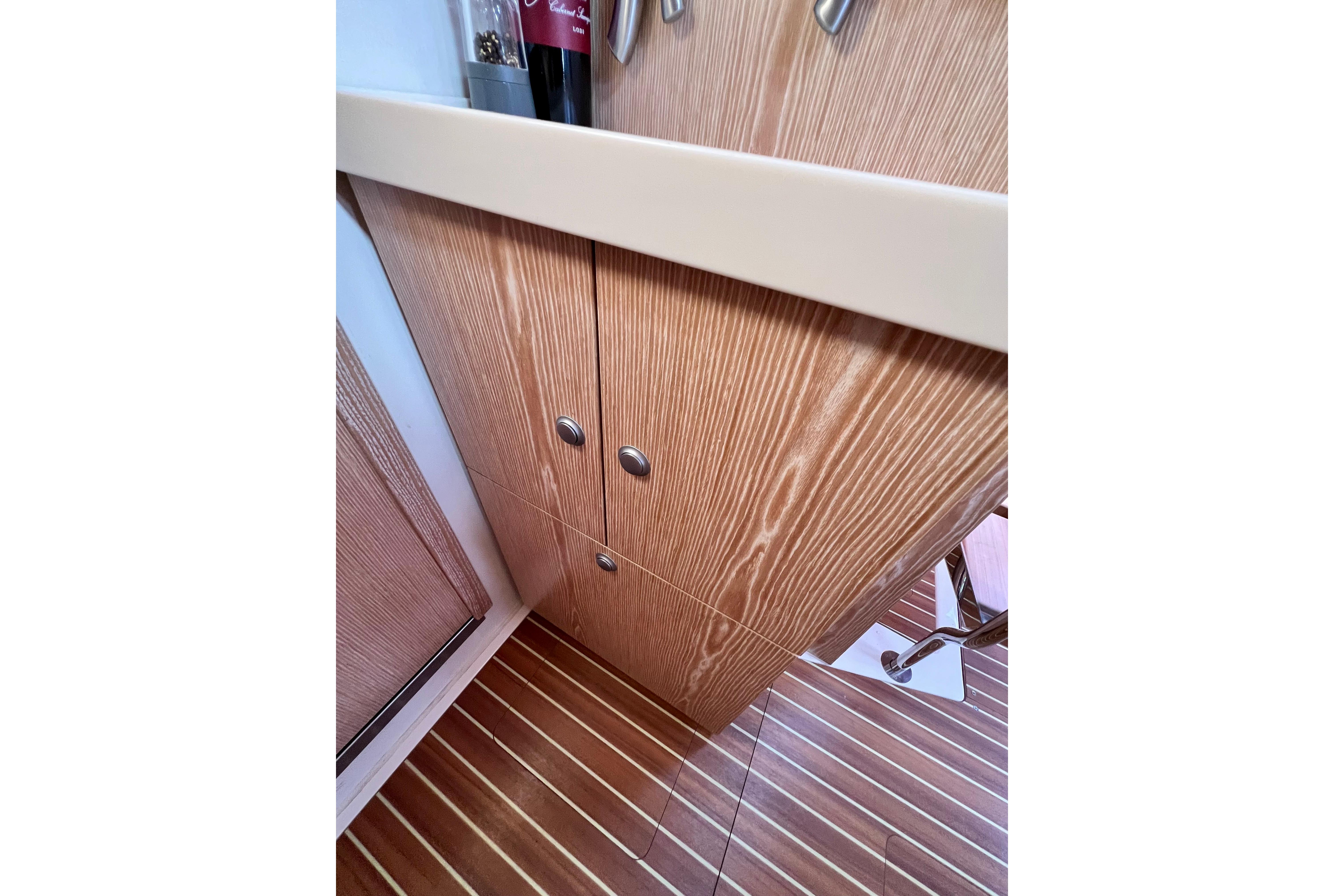 Interior of 2016 Hanse 455 yacht, featuring wooden cabinetry and striped flooring.