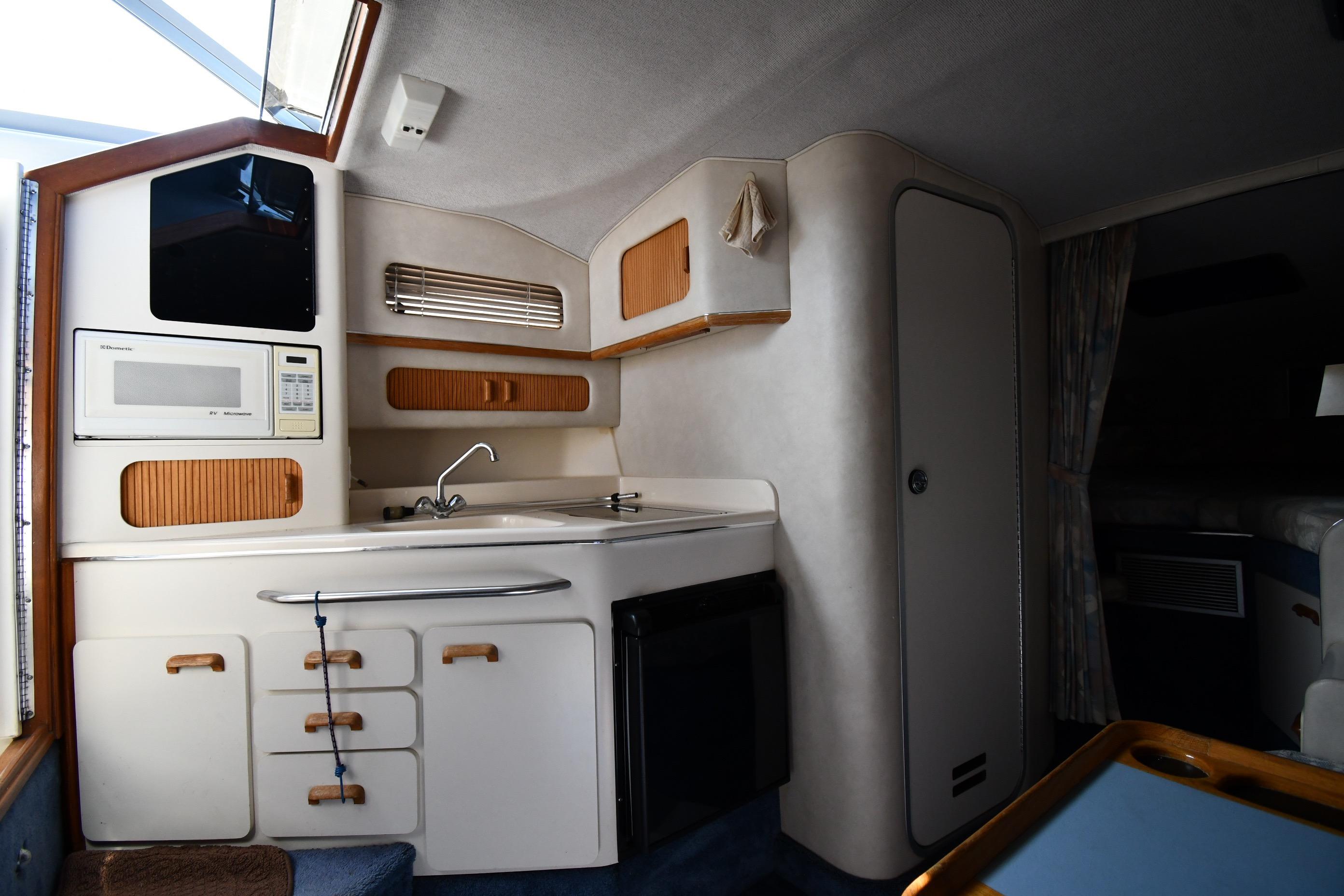 Interior of 1993 Sea Ray 300 Sundancer boat featuring a compact kitchen area.
