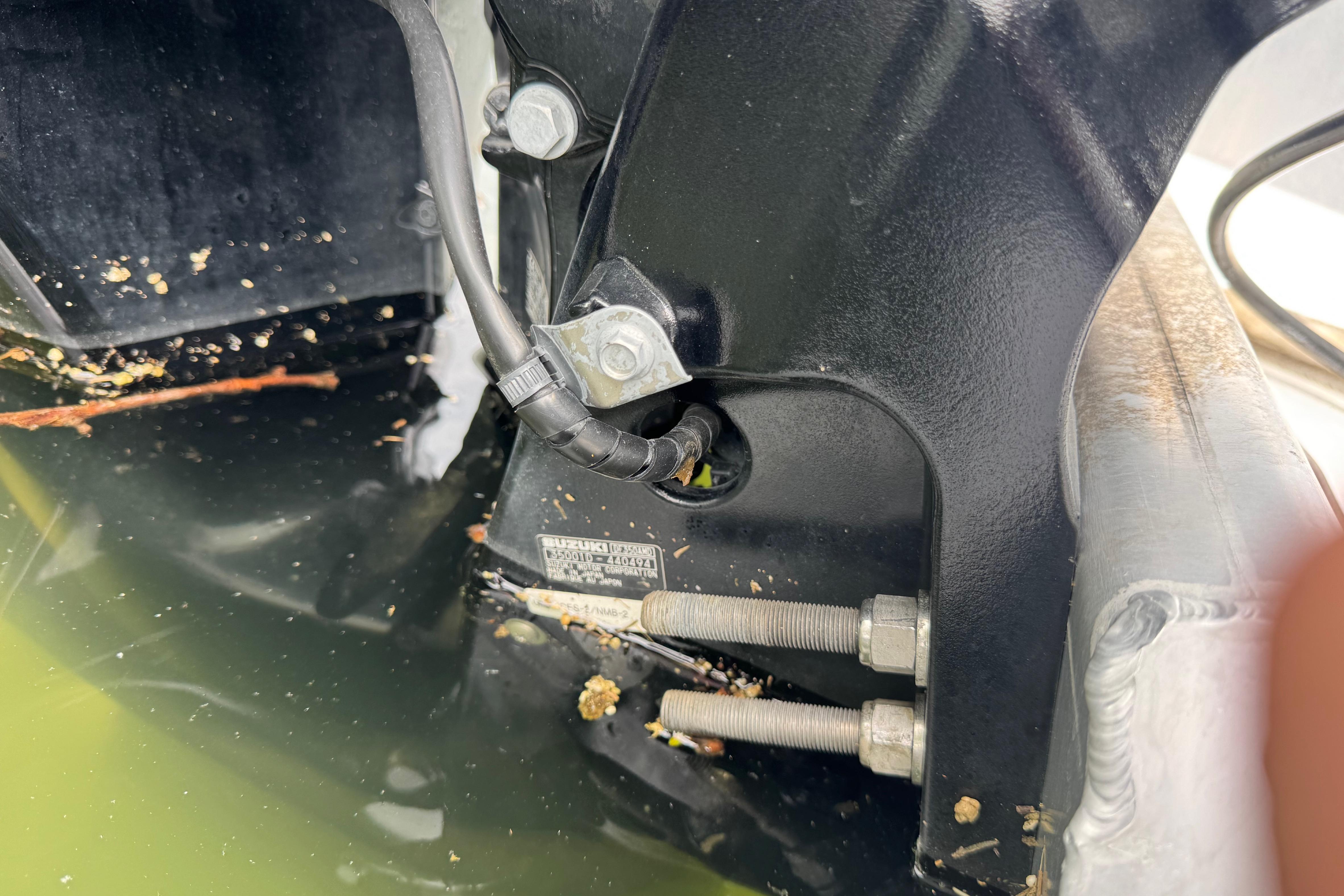 Close-up of 2023 Starcraft MX 25 DL DH boat engine mount with visible bolts and wiring.