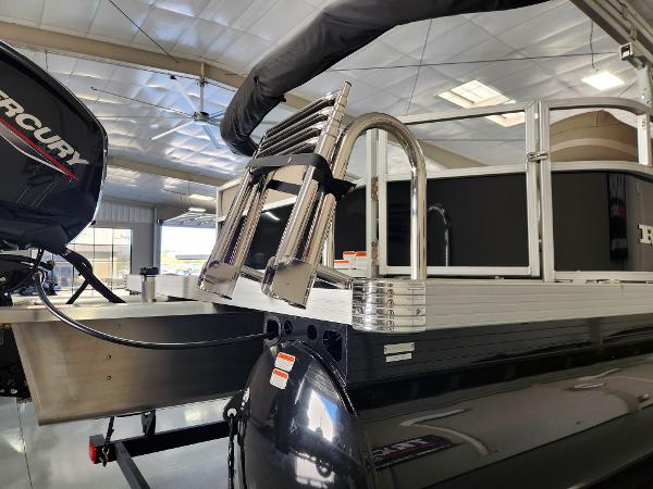 2025 Ranger 200C boat with Mercury engine in showroom, featuring a stainless steel ladder.