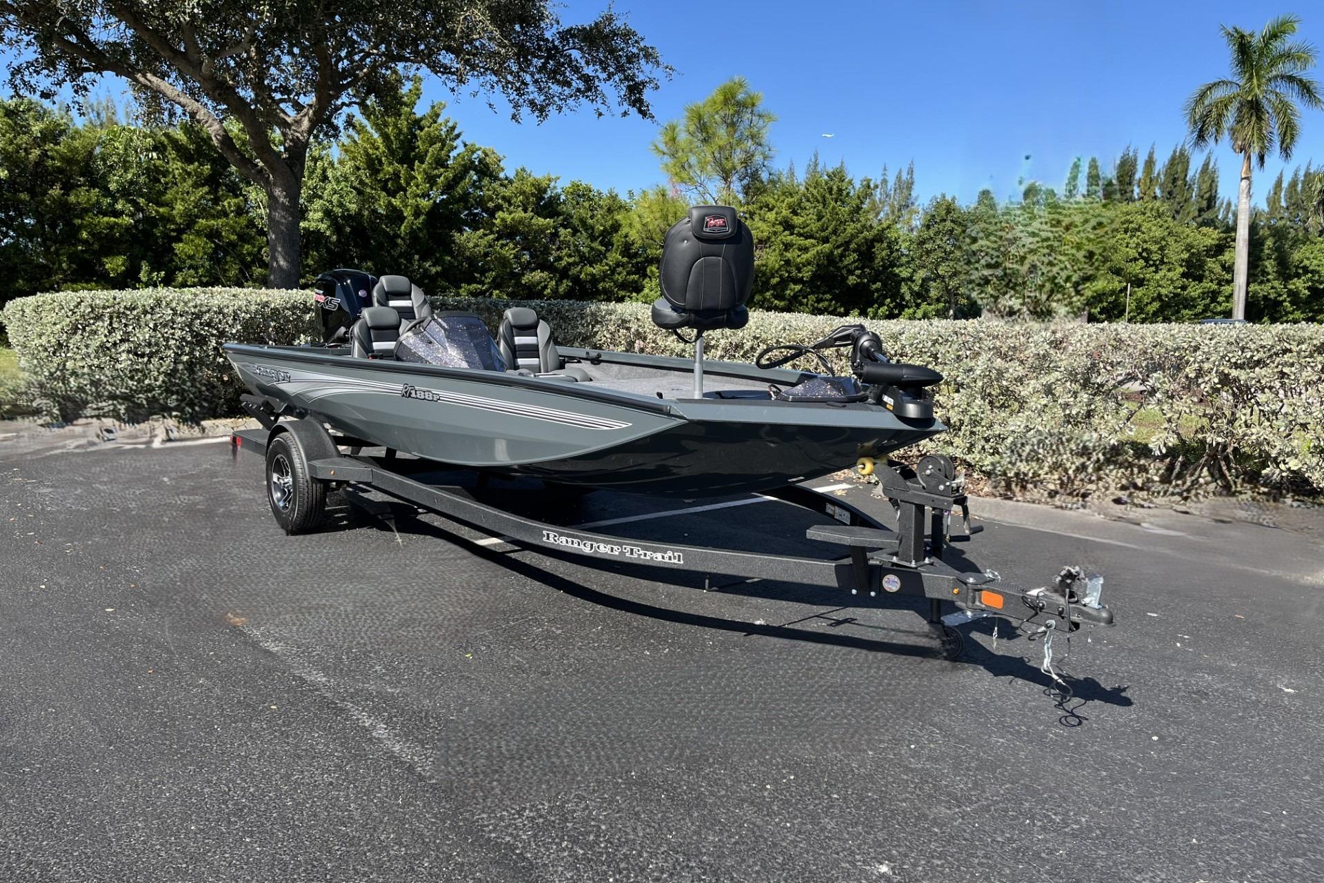 2026 Ranger RT188P fishing boat on trailer, parked outdoors, surrounded by greenery.
