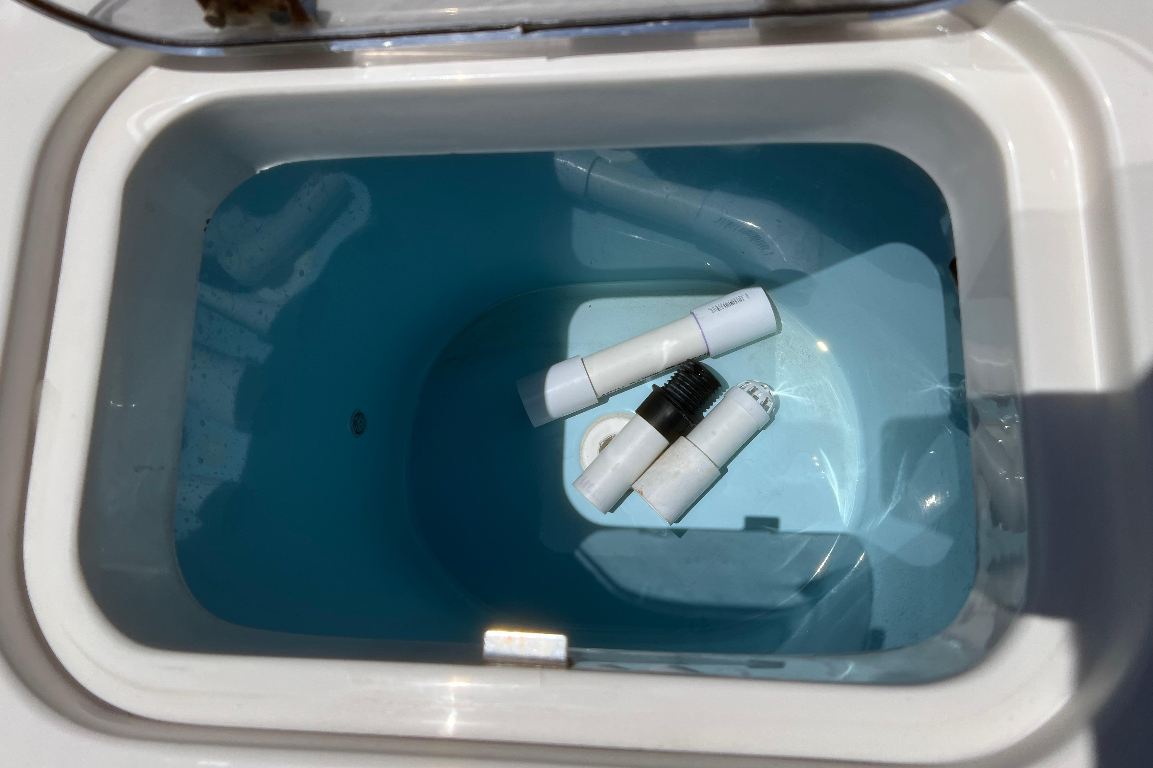 Livewell compartment in 2018 Cobia 201 Center Console boat with fittings inside.
