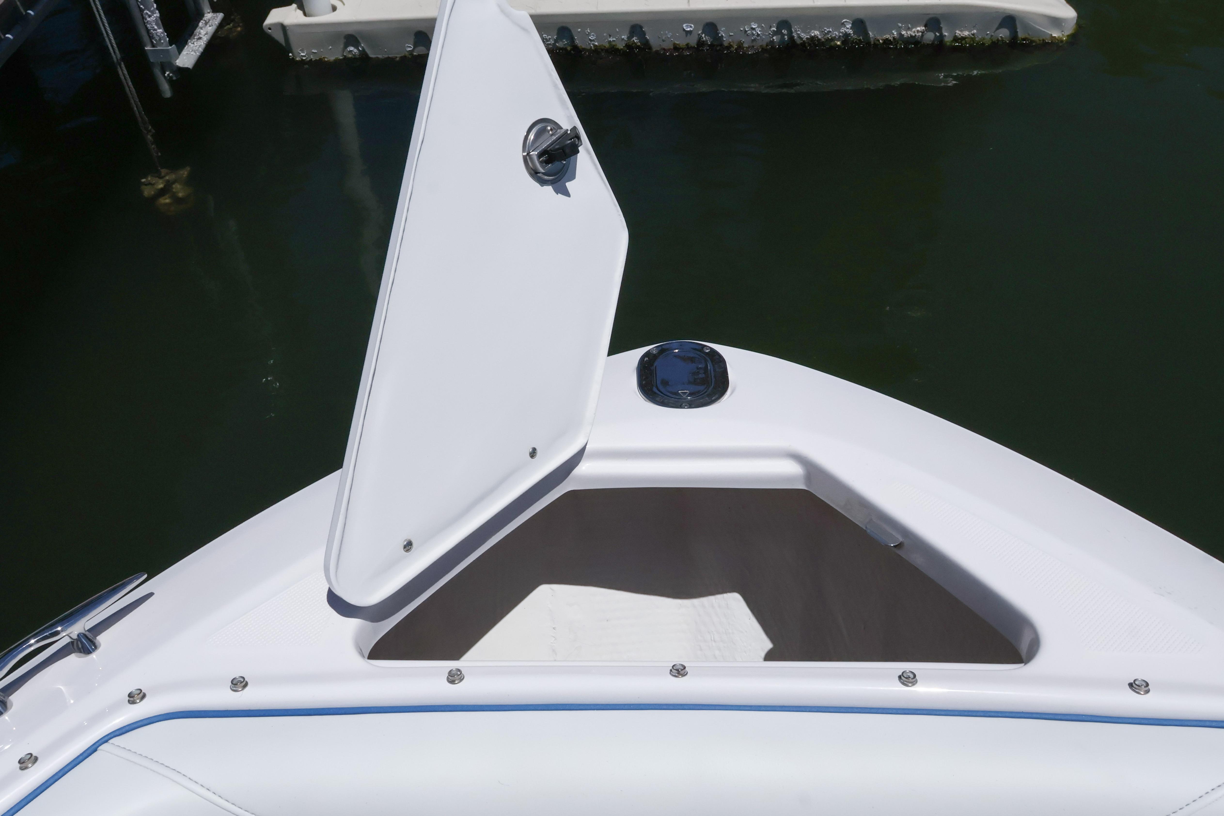 Open storage compartment on 2020 Regal LX4 boat, docked on calm water.