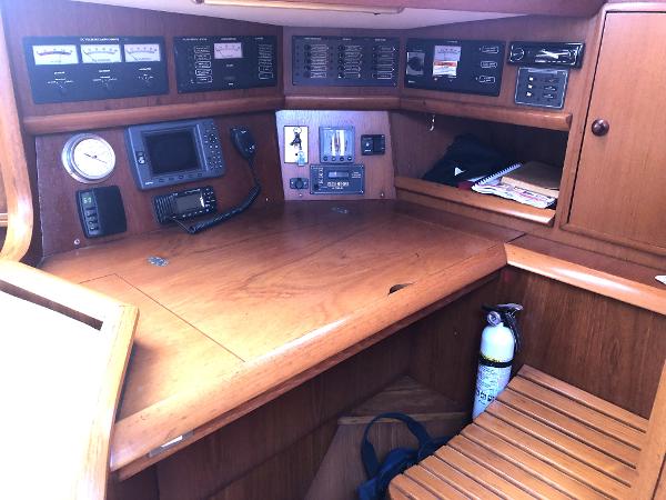 Navigation station of a 2001 Jeanneau 45.2 sailboat with control panels and equipment.