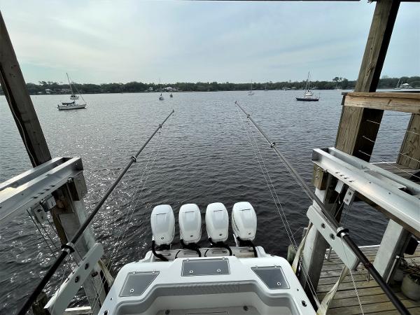 2020 Front Runner 39 Center Console boat with four engines docked by a lake.
