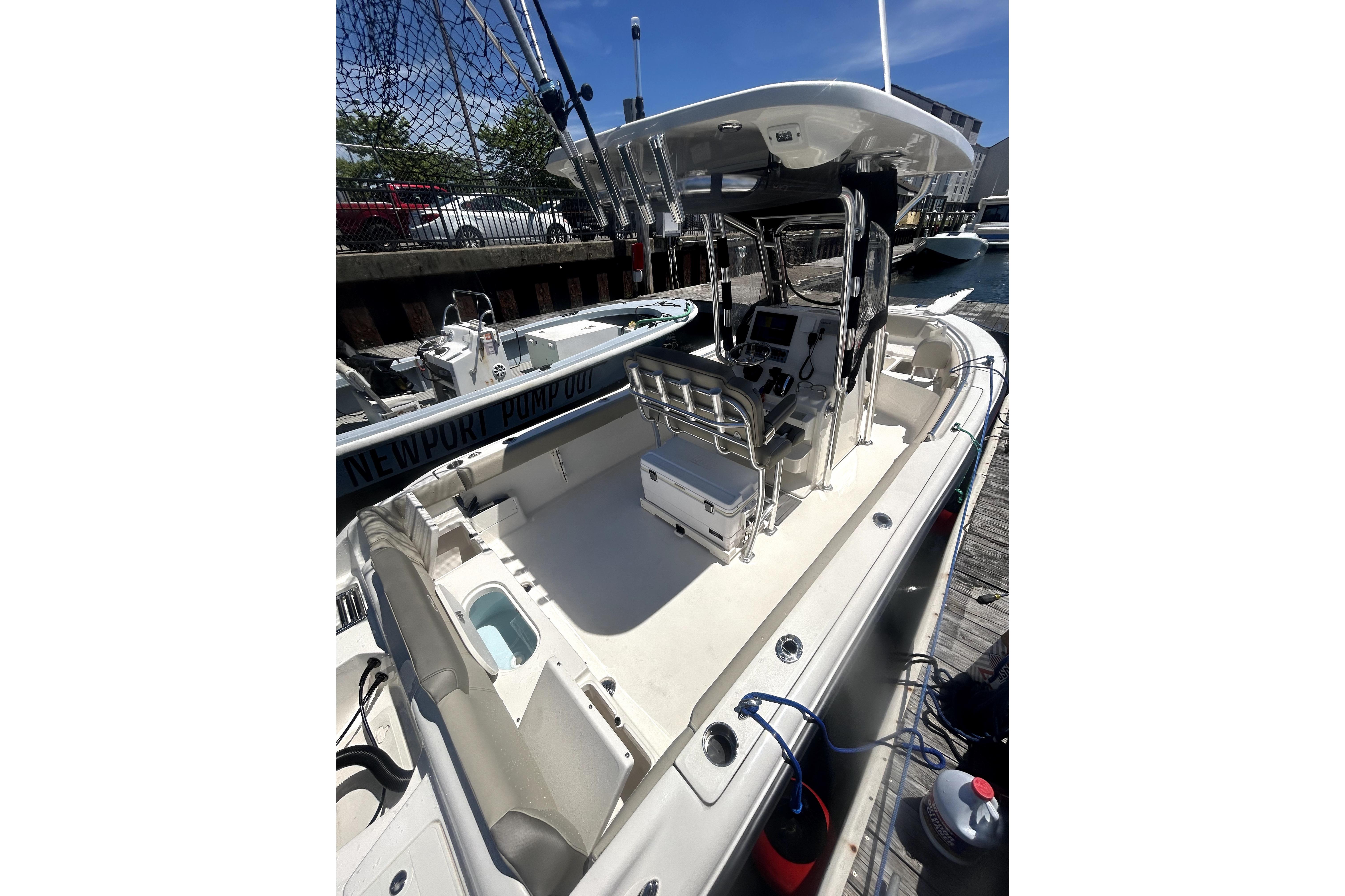 2023 Key West 239 FS boat docked, featuring spacious deck and modern controls.