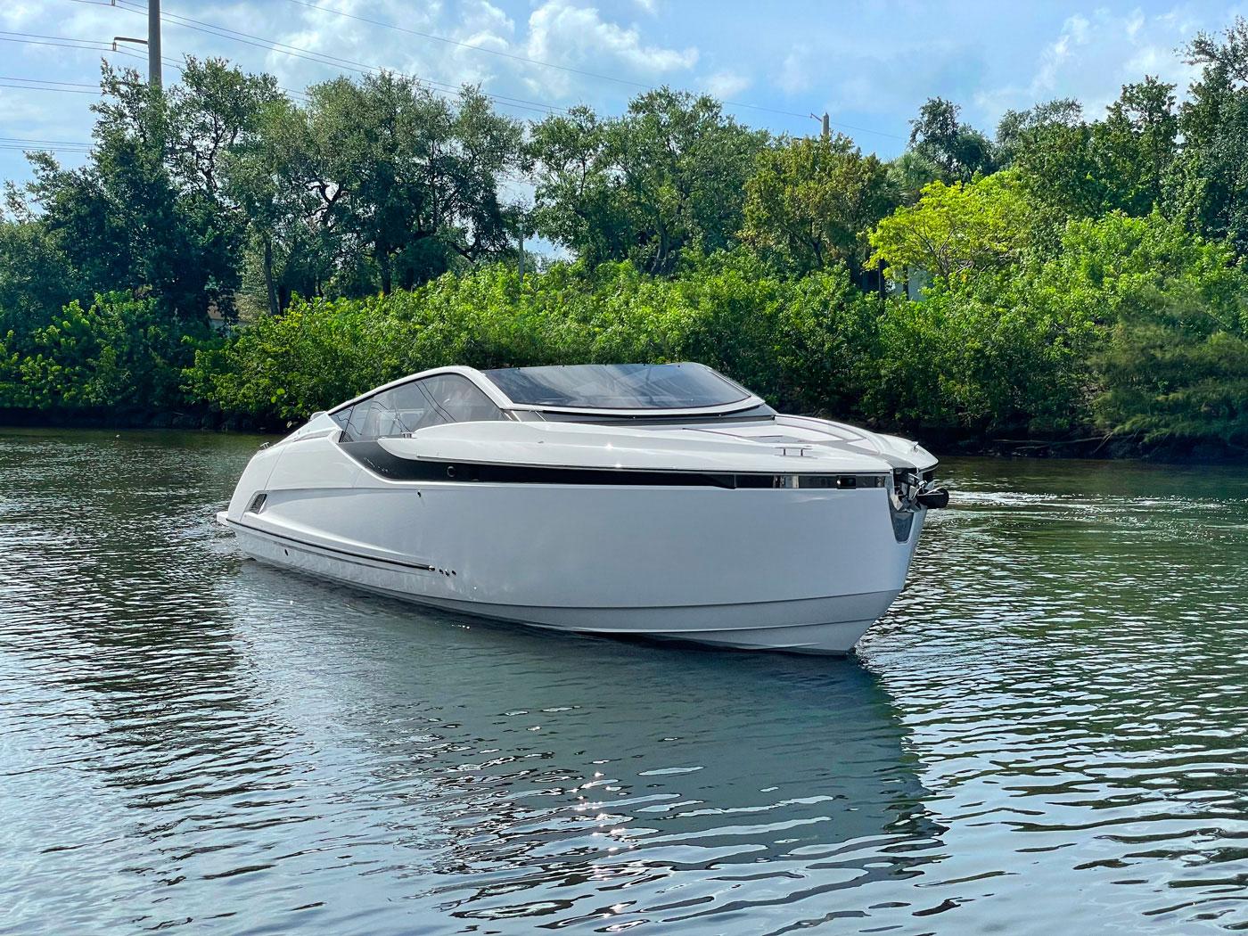2021 Fairline F Line 33 luxury yacht on calm water with lush greenery background.