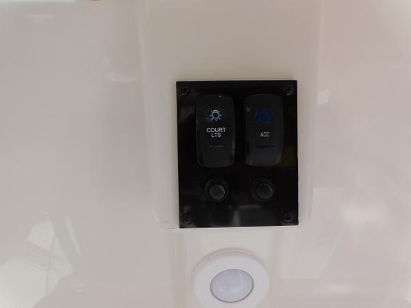 Switch panel on 2024 Sailfish 242 CC boat with court lights and accessory buttons.