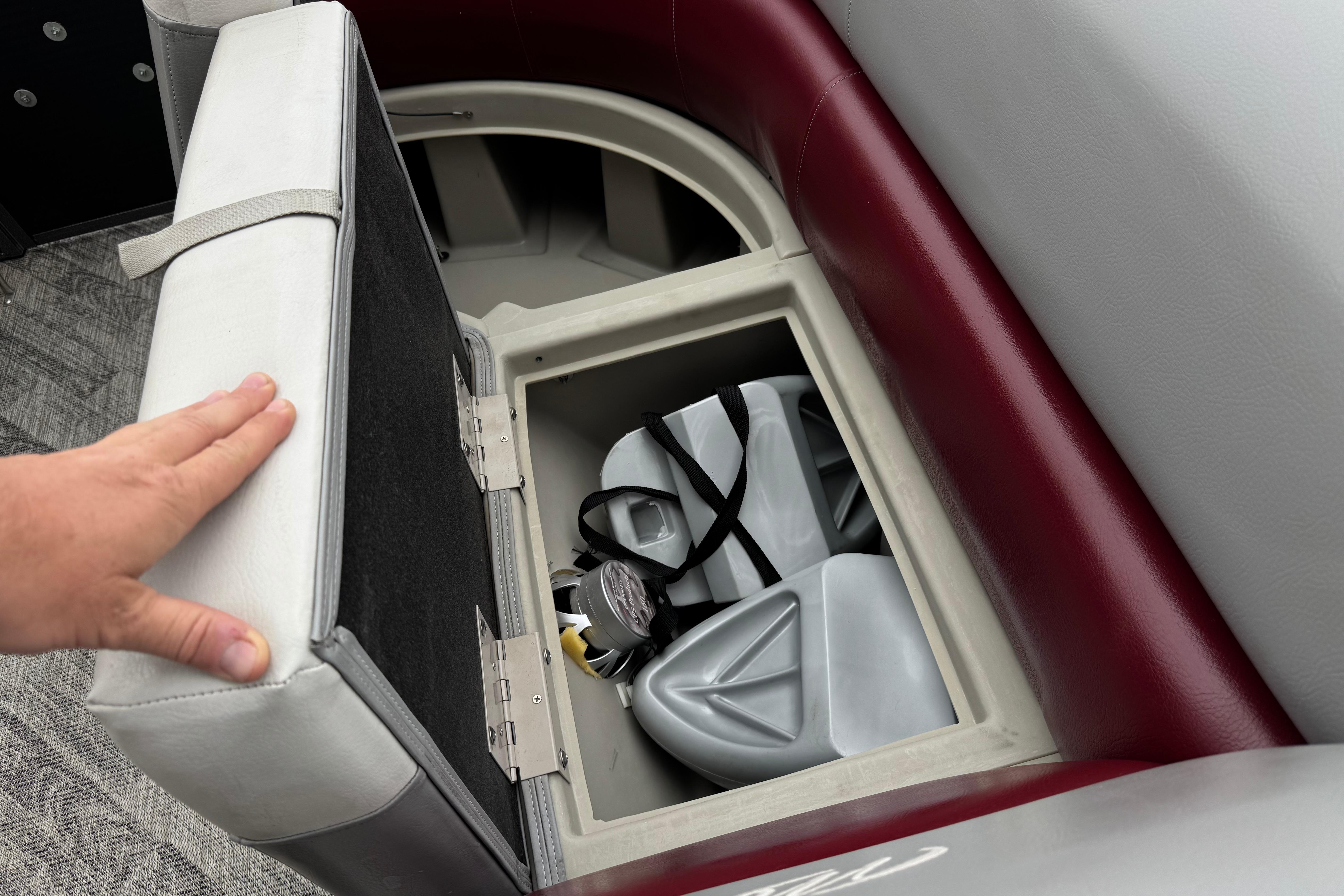 Storage compartment in 2020 Manitou 18 Aurora LE boat with life jackets inside.