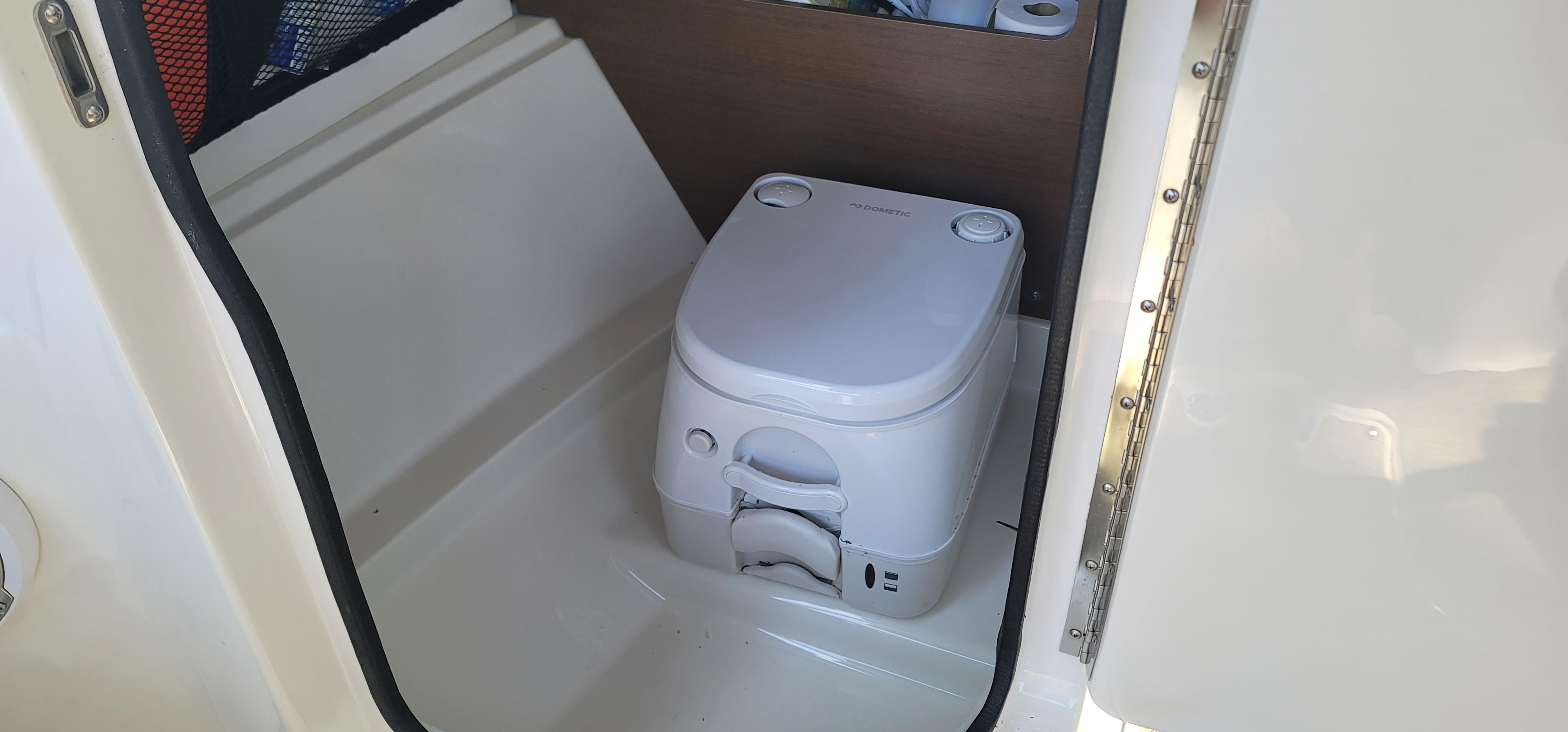 Portable toilet inside 2017 Sea Ray SDX 240 Outboard boat cabin.