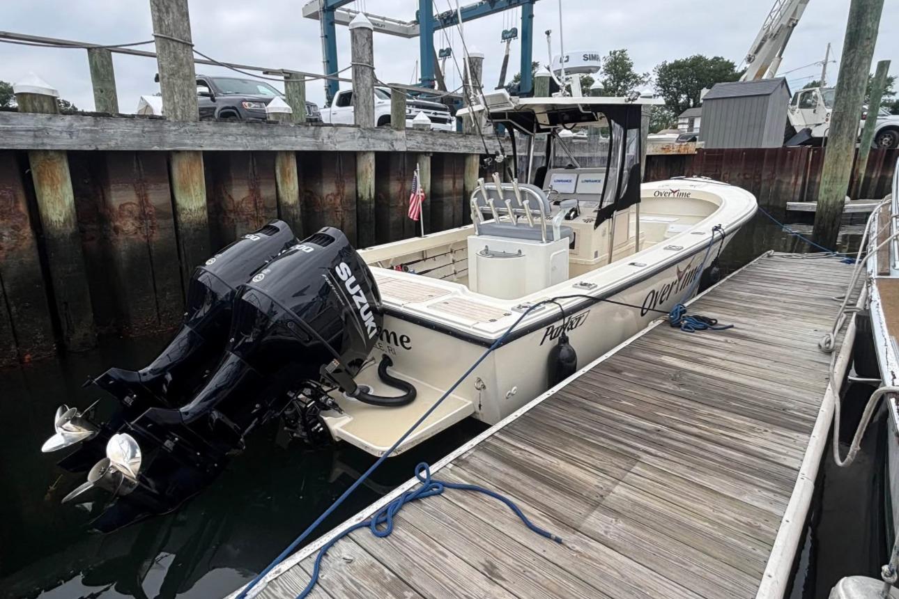 1999 Parker 2501 Center Console boat docked with twin Suzuki outboard engines.