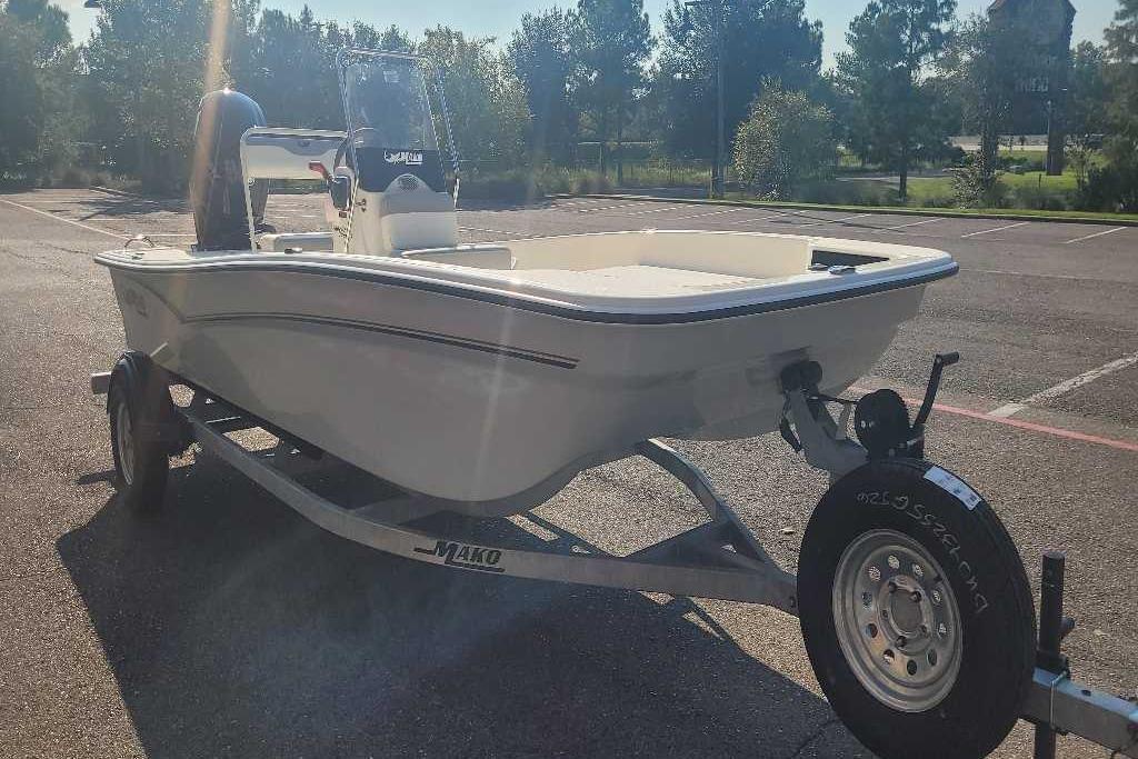 2026 Mako Pro Skiff 17 CC boat on trailer in parking lot, sunny day.