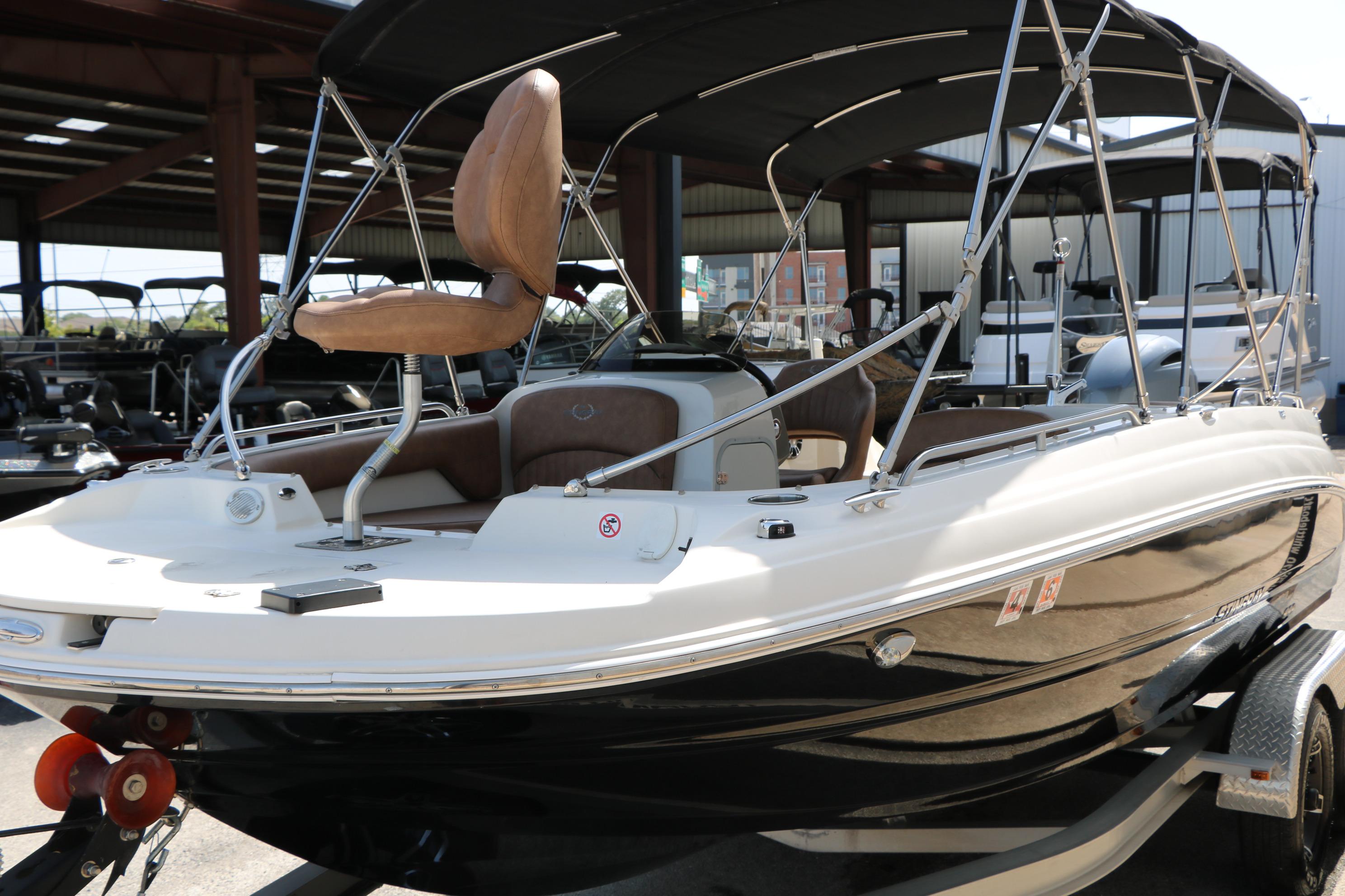 2022 Stingray 192 SC boat with canopy, displayed in a showroom setting.
