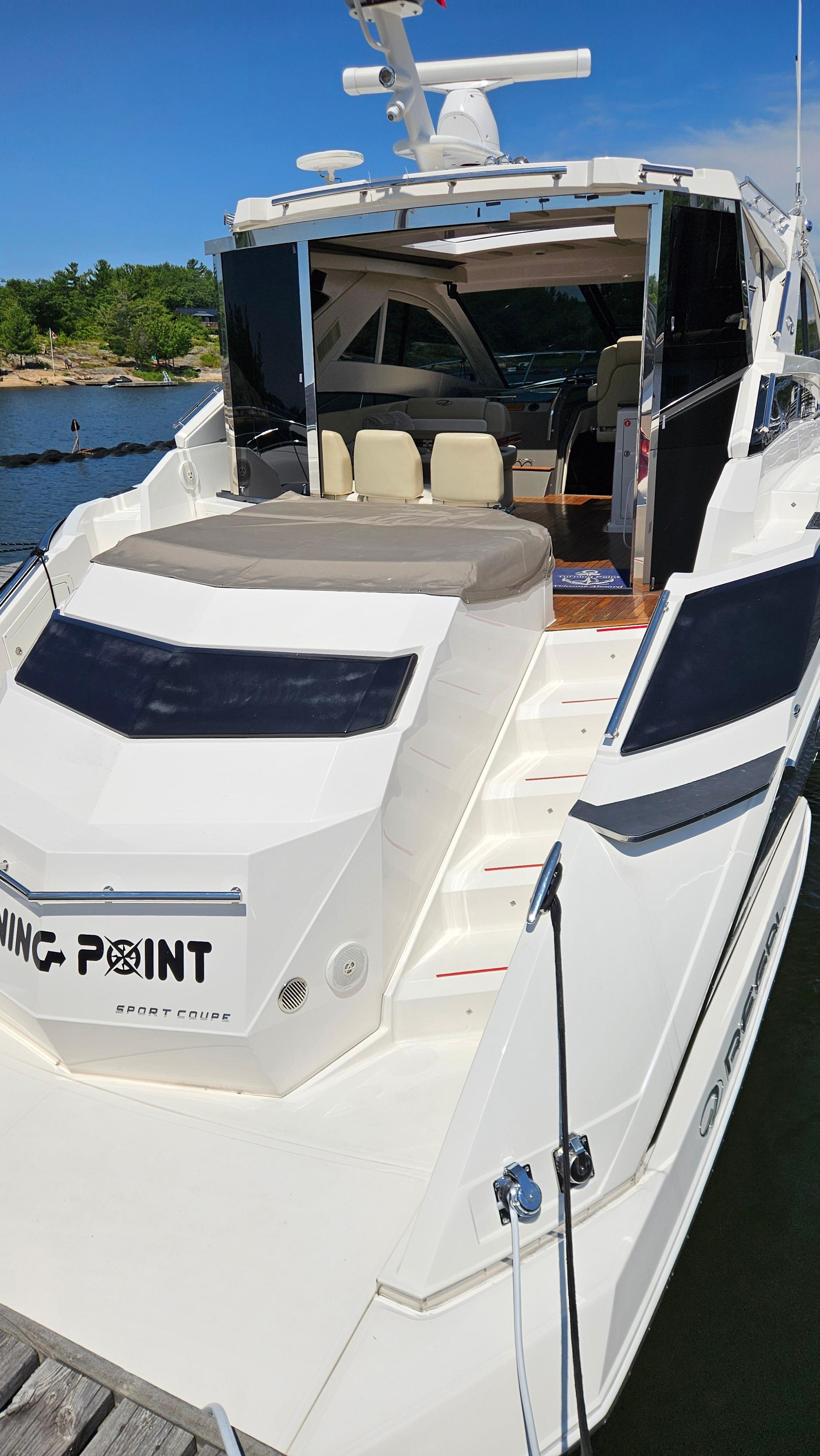 2012 Regal 52 Sport Coupe yacht docked, featuring sleek design and spacious seating area.