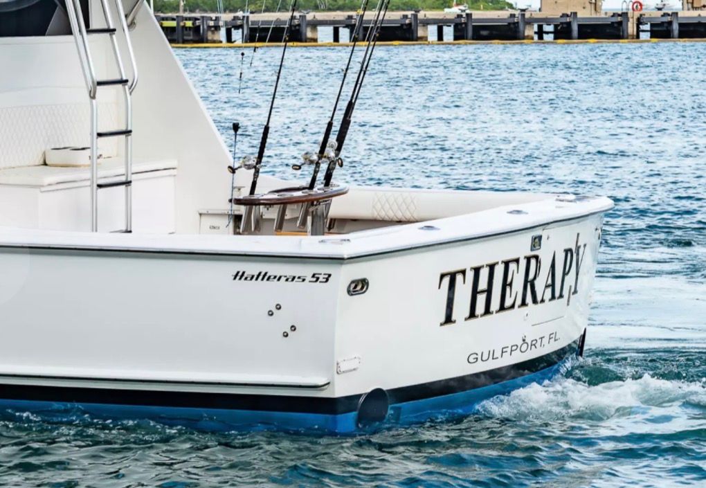 The image shows a 1979 Hatteras sport fishing boat on the water.