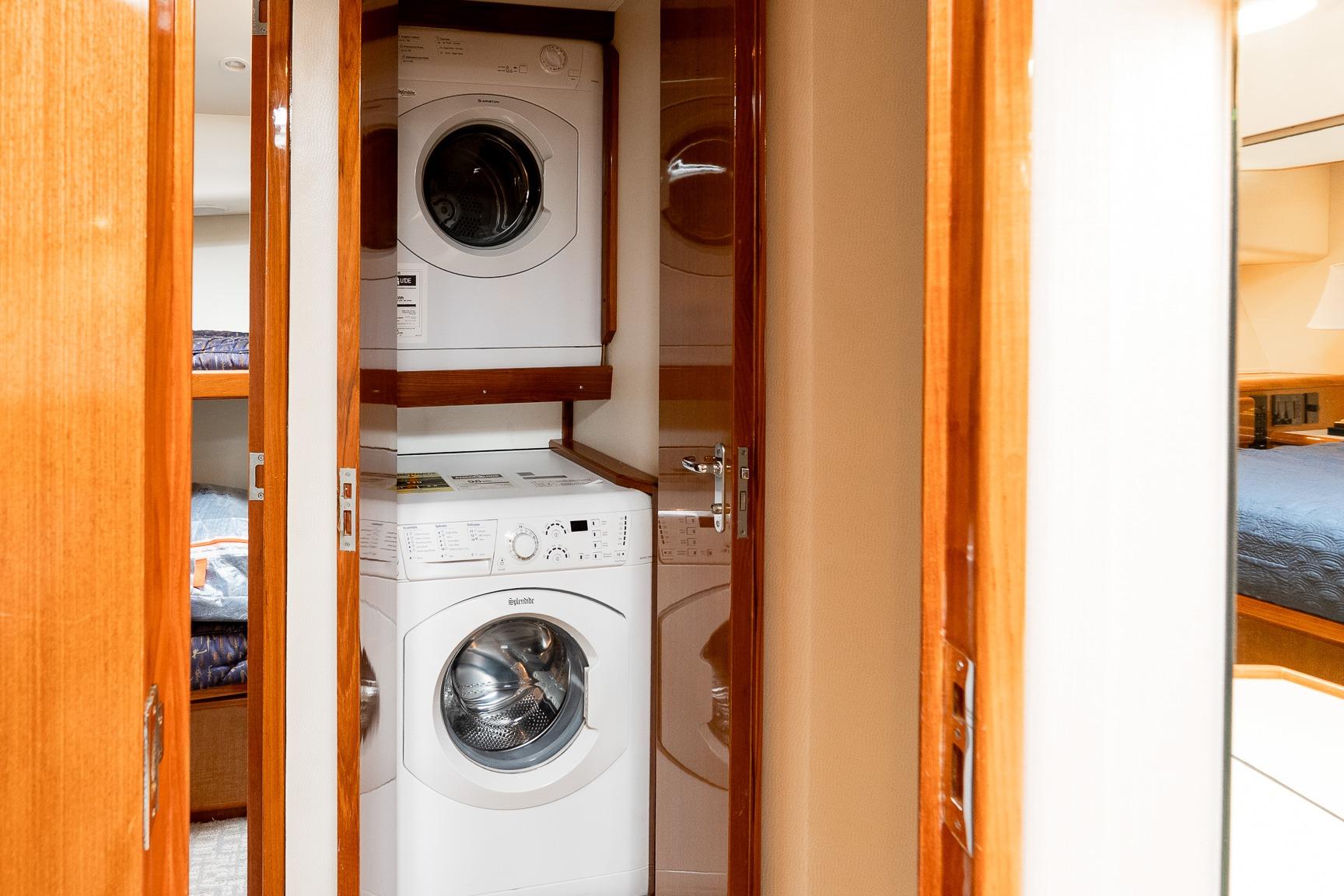 Laundry area with stacked washer and dryer on 2000 Viking 50' Convertible yacht.