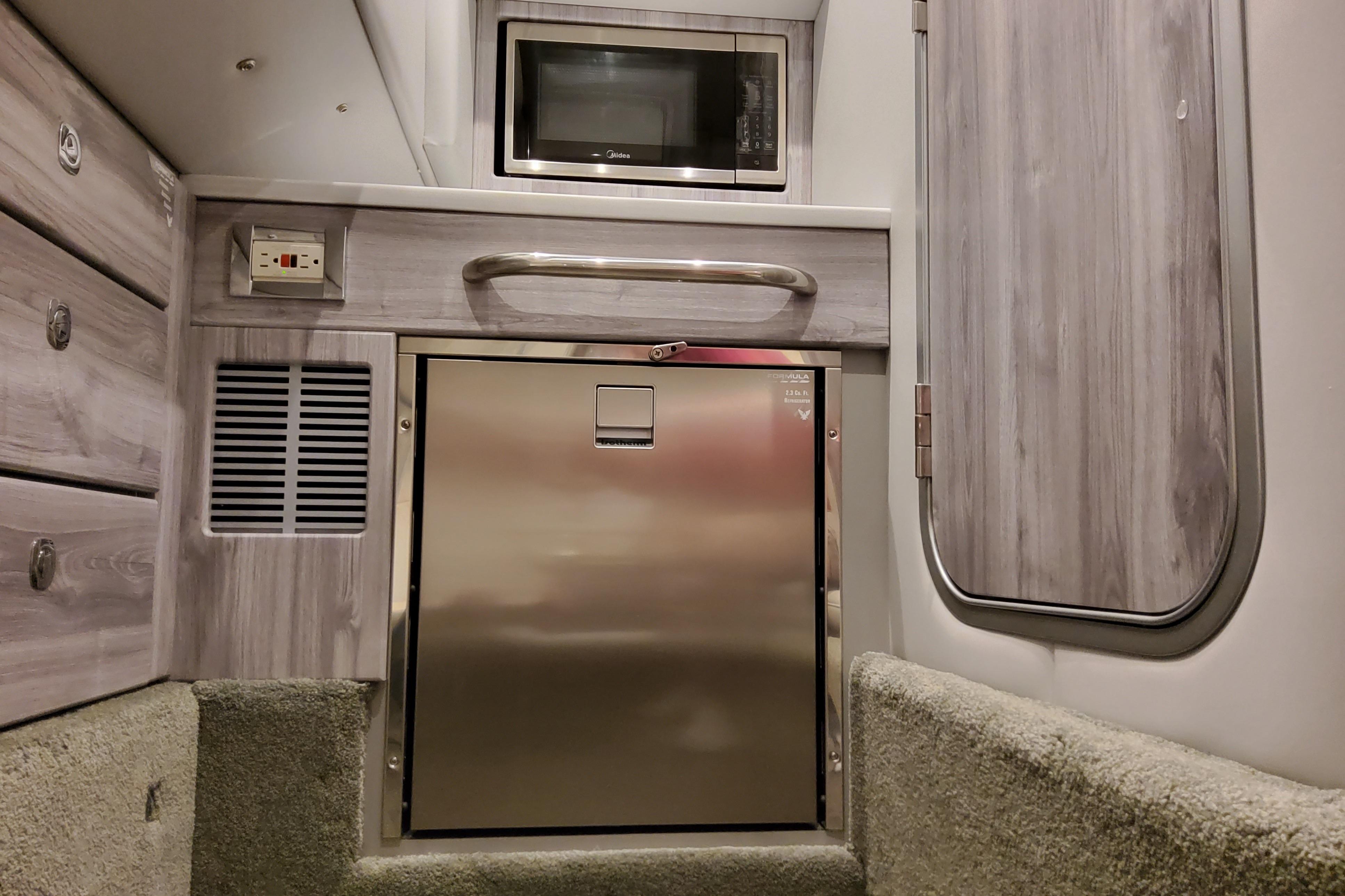 2027 Formula 350 Crossover Bowrider I/O interior with microwave and stainless steel fridge.