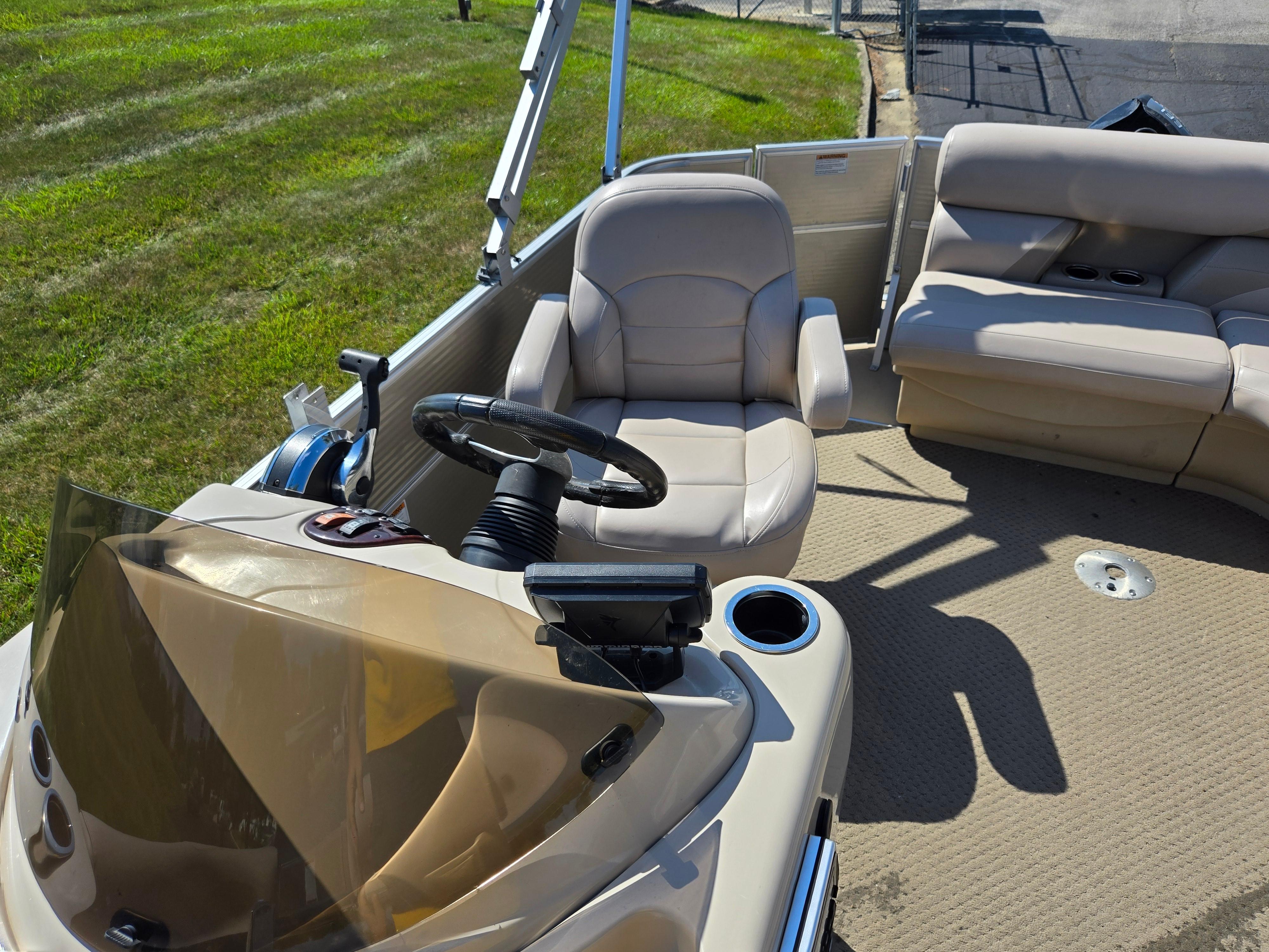 2013 Starcraft Stardeck 190 Cruise interior with beige seating and steering console.