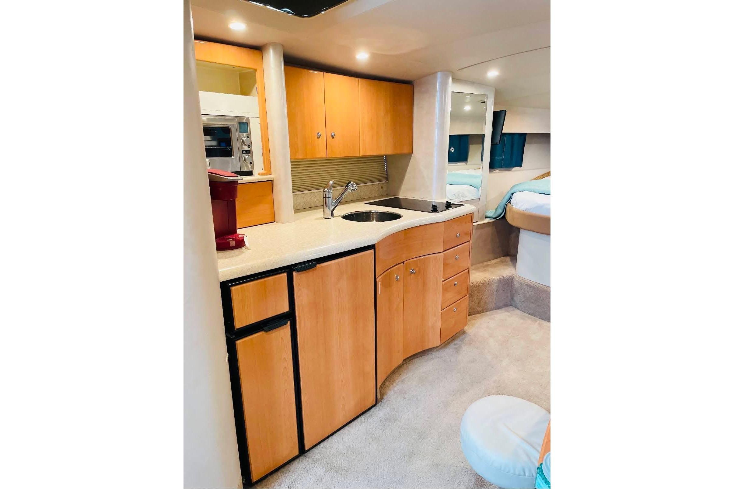 Interior of 2003 Formula 40 Performance Cruiser with kitchenette and cozy cabin space.