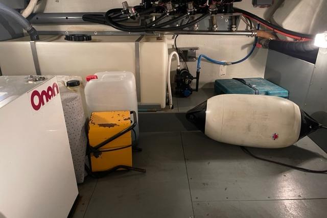Engine room of a 1998 Storebro 430 Royal Cruiser with equipment and storage containers.