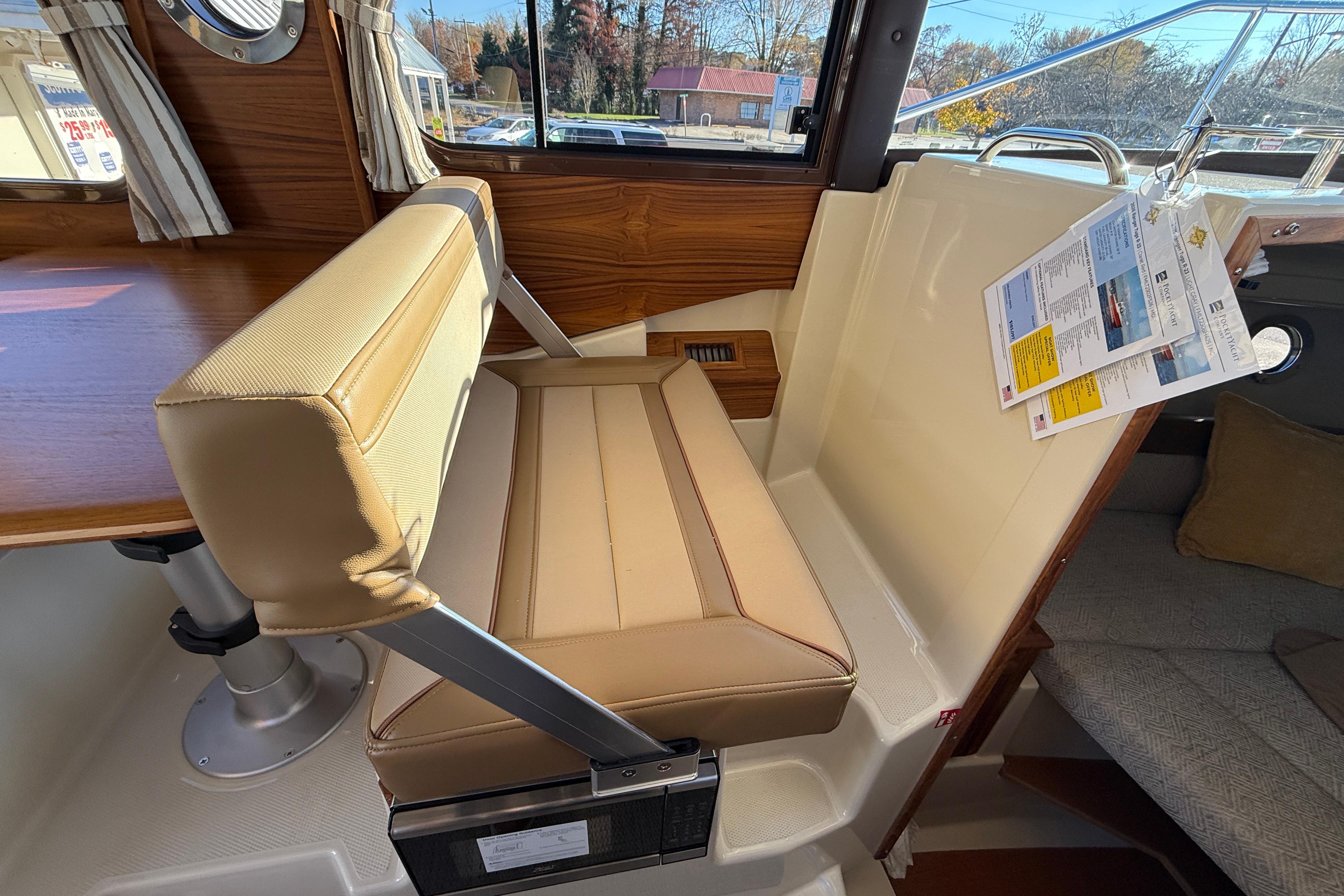 2026 Ranger Tugs R-23 interior with beige seating and wooden accents.