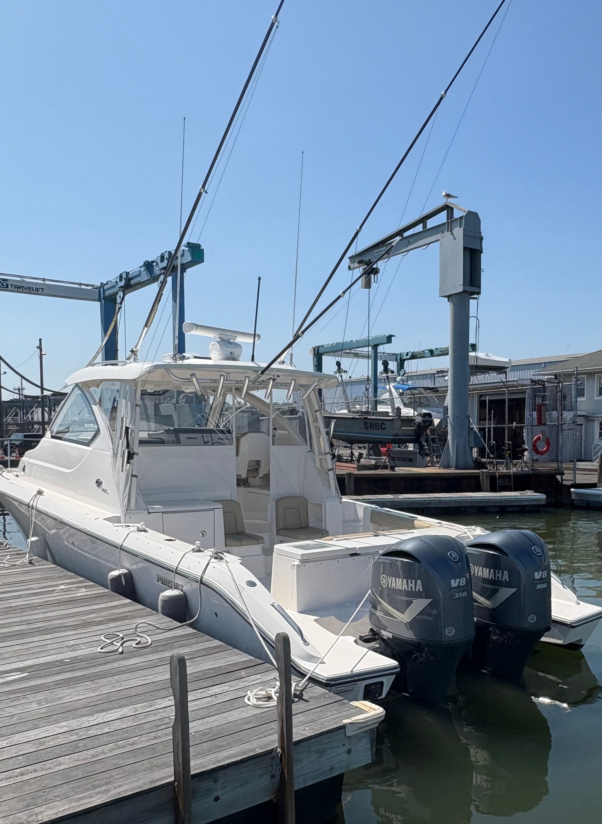 2017 Pursuit OS 355 Offshore boat docked with twin Yamaha engines.