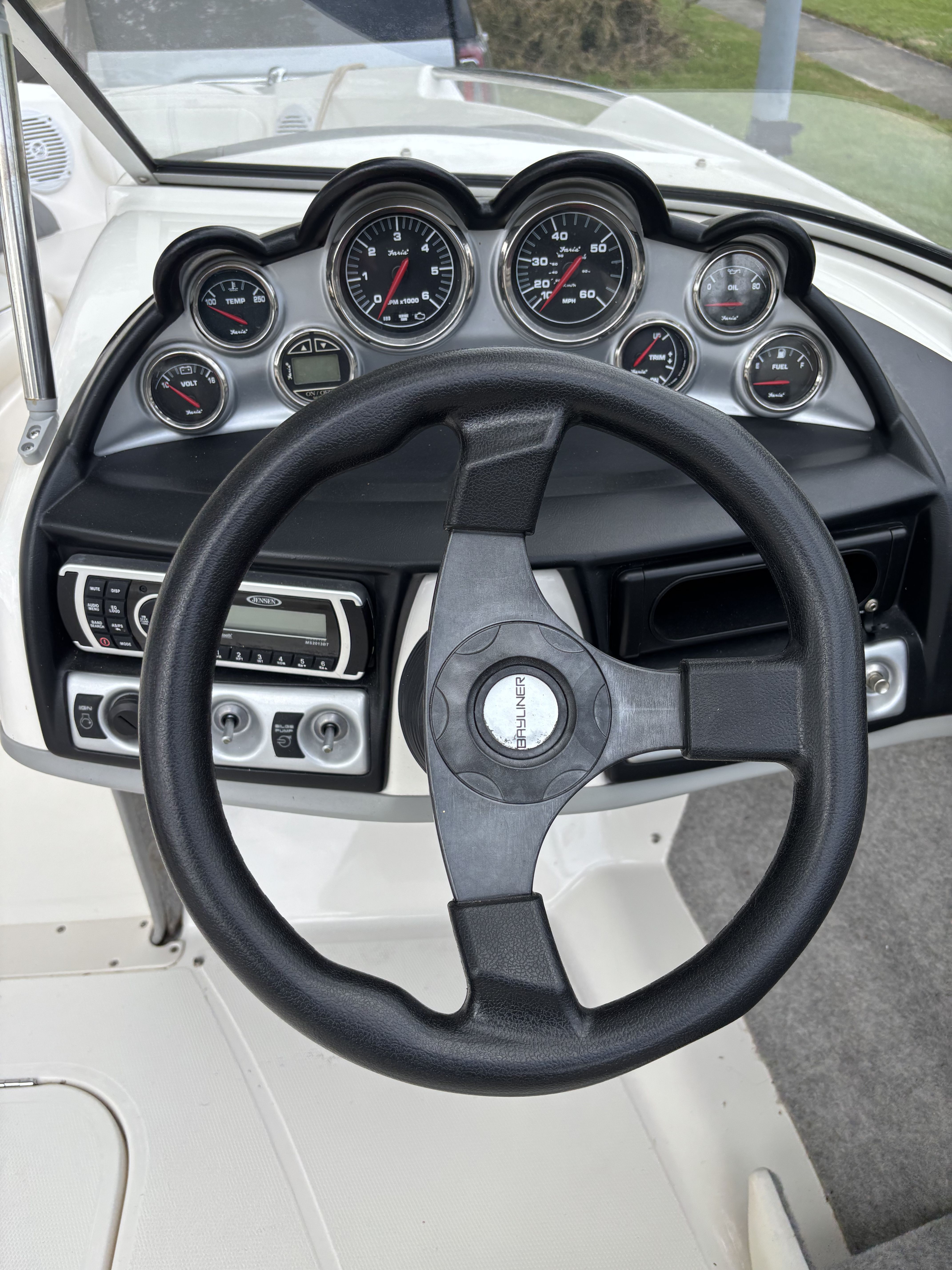 The dashboard of a Bayliner 215 Bowrider with multiple gauges and a steering wheel.
