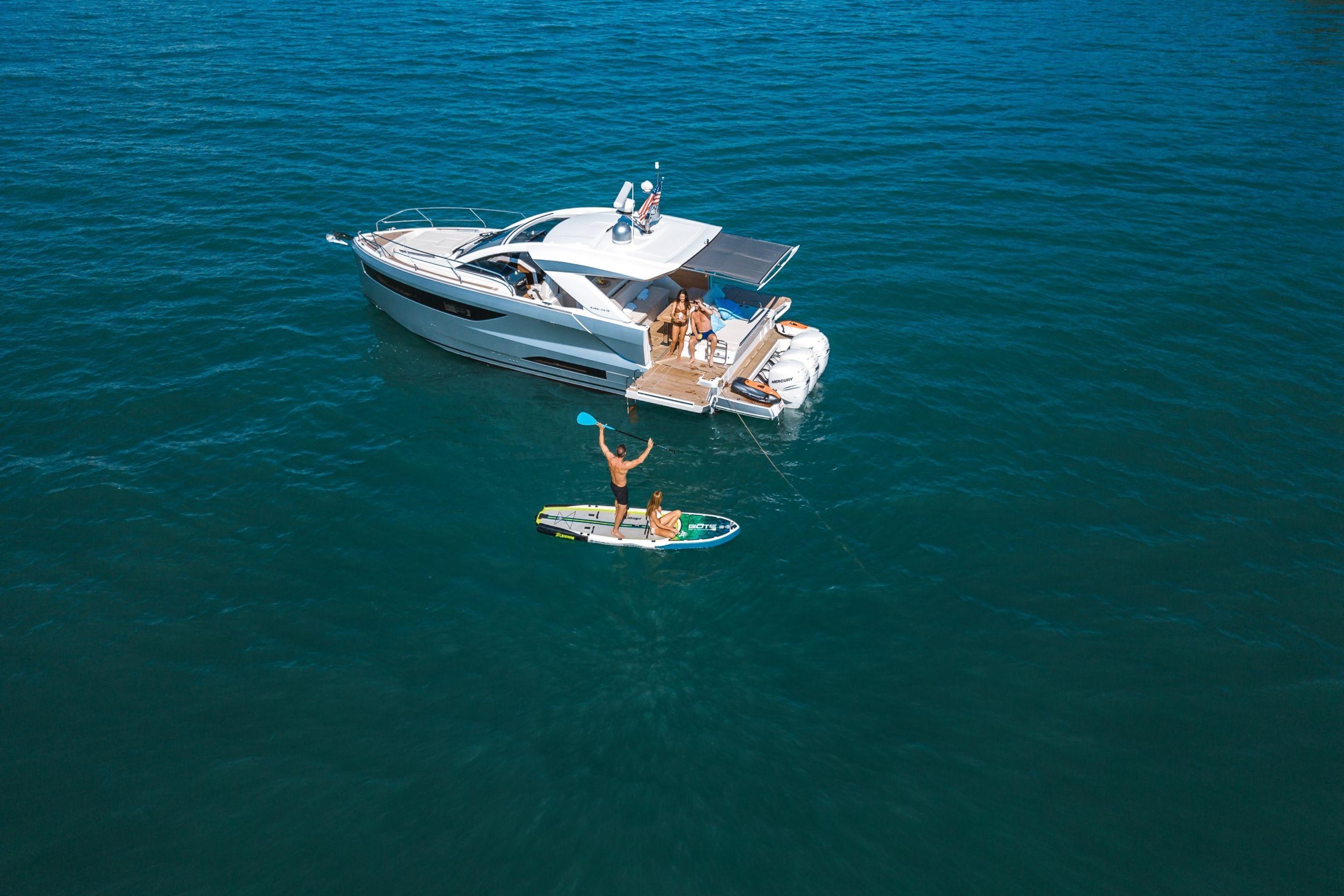 2025 Jeanneau DB/43 OB yacht with paddleboarders on open water.