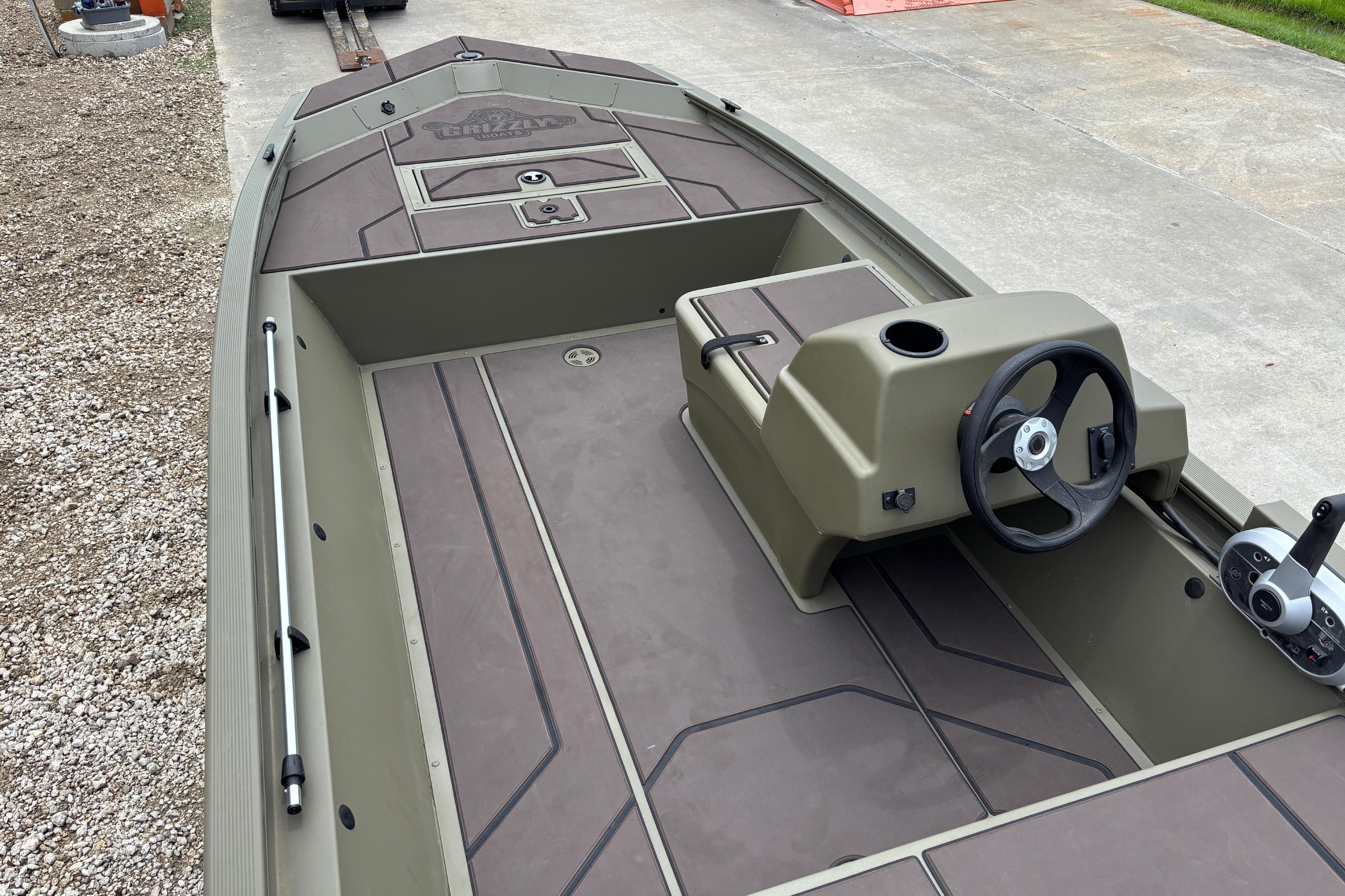 2026 Tracker Grizzly 1648 SC boat interior with steering console and spacious deck.