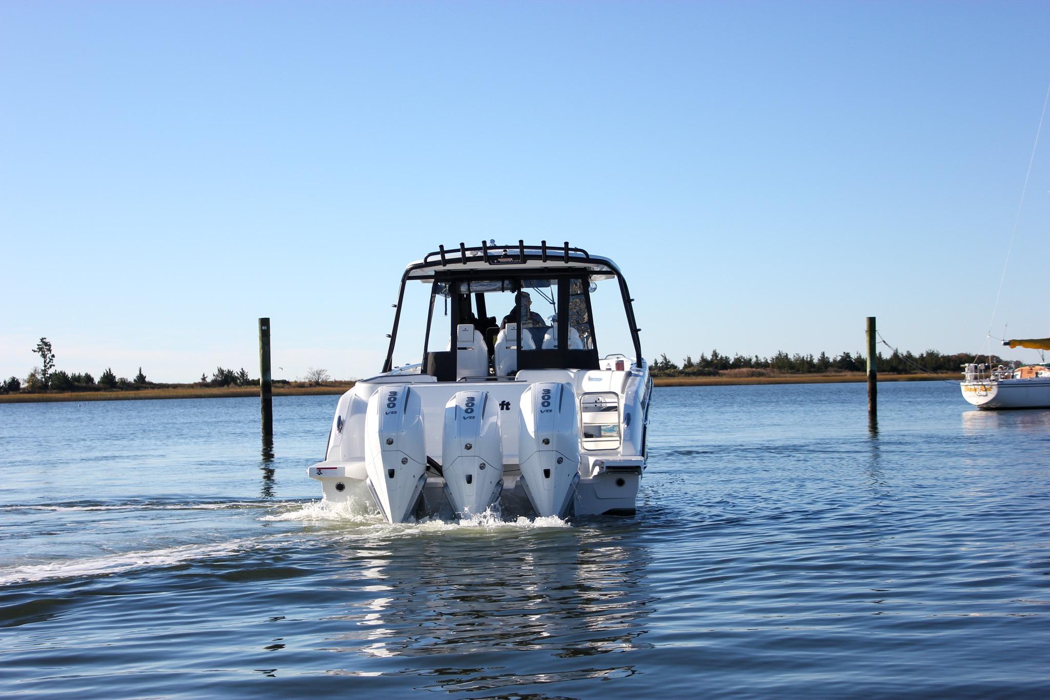 2026 Wellcraft 38 T-Top boat with triple engines cruising on calm water.