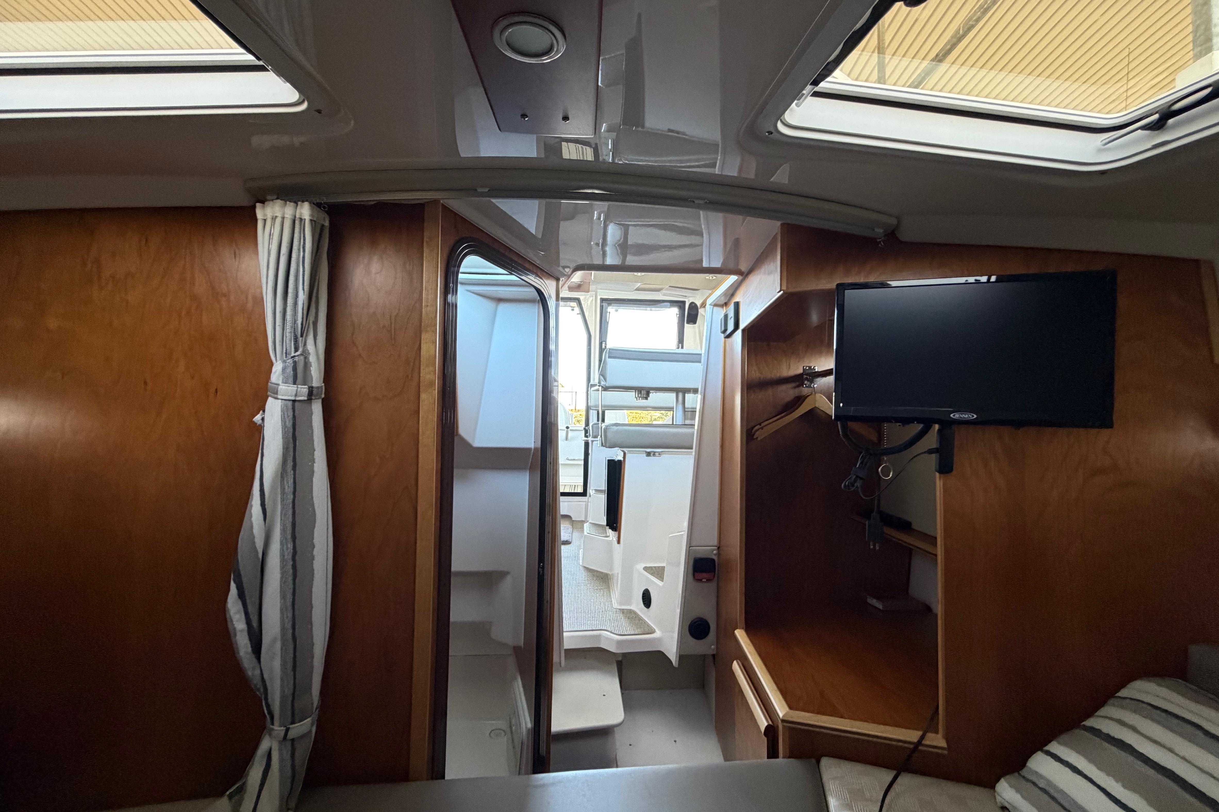 Interior of 2023 Cutwater C-288 Coupe boat with wood finish and mounted TV.