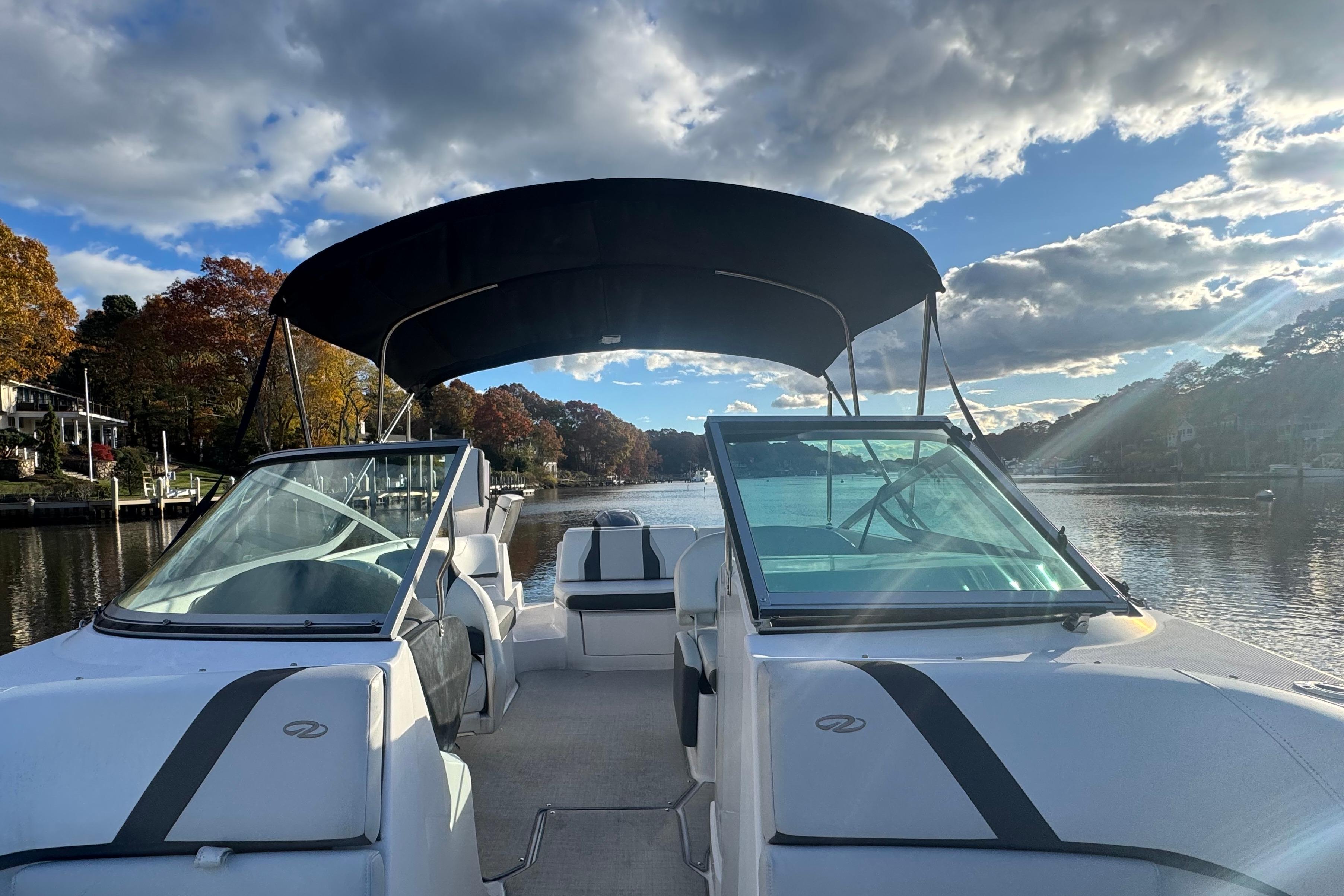 2017 Regal 23 OBX boat on a scenic river with autumn foliage and blue sky.