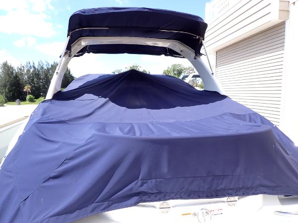 2011 Chaparral 287 SSX boat with blue cover, parked near a building.