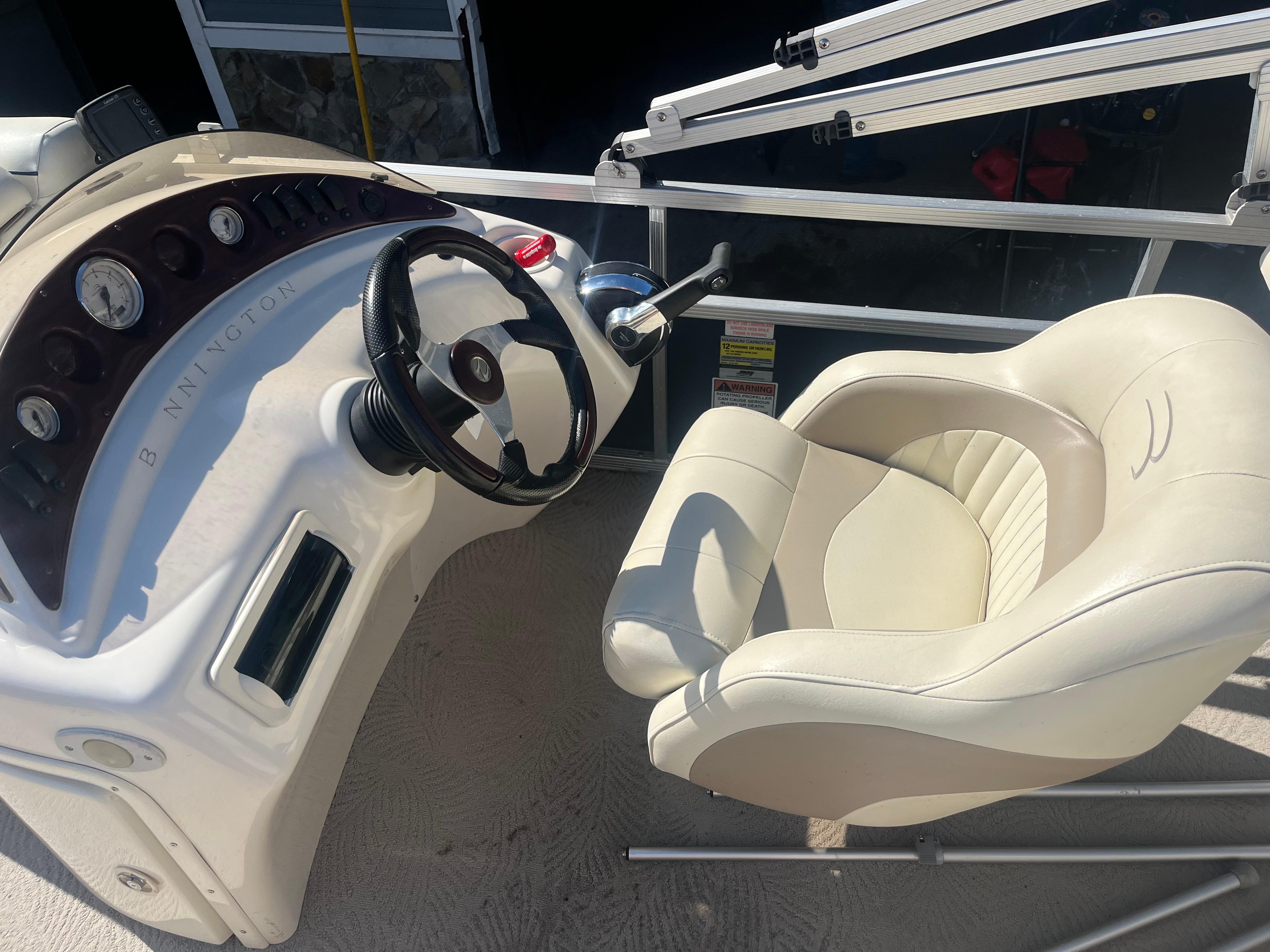 2009 Bennington 2275 GS boat helm with steering wheel and captain's chair.