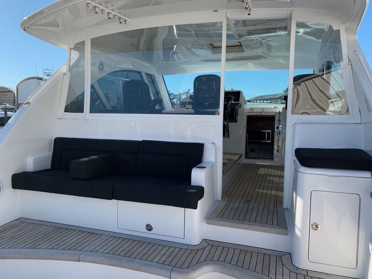 The image shows the cockpit of a 2018 Hatteras 45 Express Sportfish with black seating.