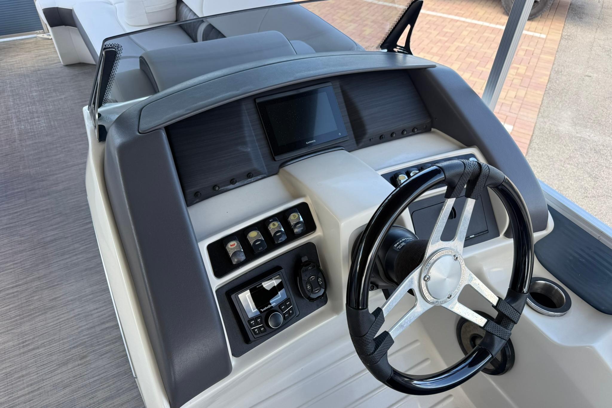 2022 Bennington LX 26 Swingback boat dashboard with steering wheel and control panel.