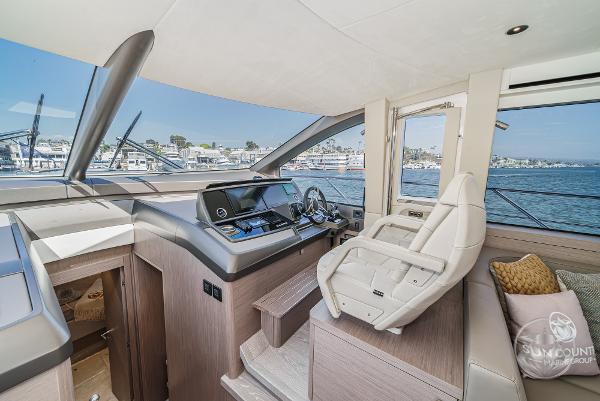 Interior helm of 2025 Sunseeker Manhattan 68 yacht, featuring modern controls and luxurious seating.
