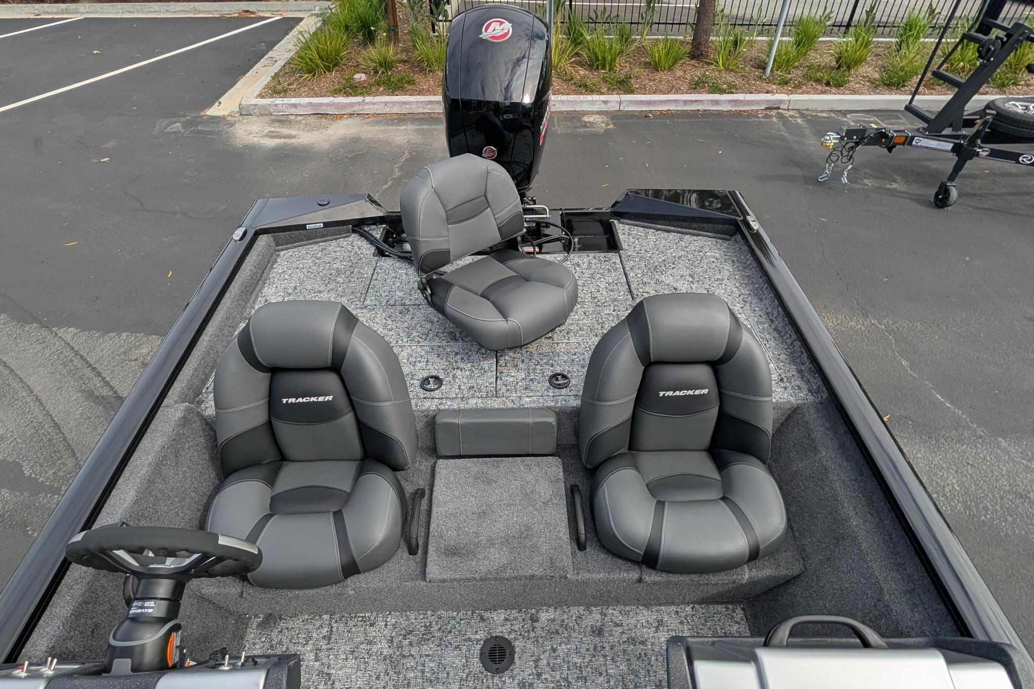 2026 Tracker Pro Team 195 boat interior with three gray seats and steering wheel.