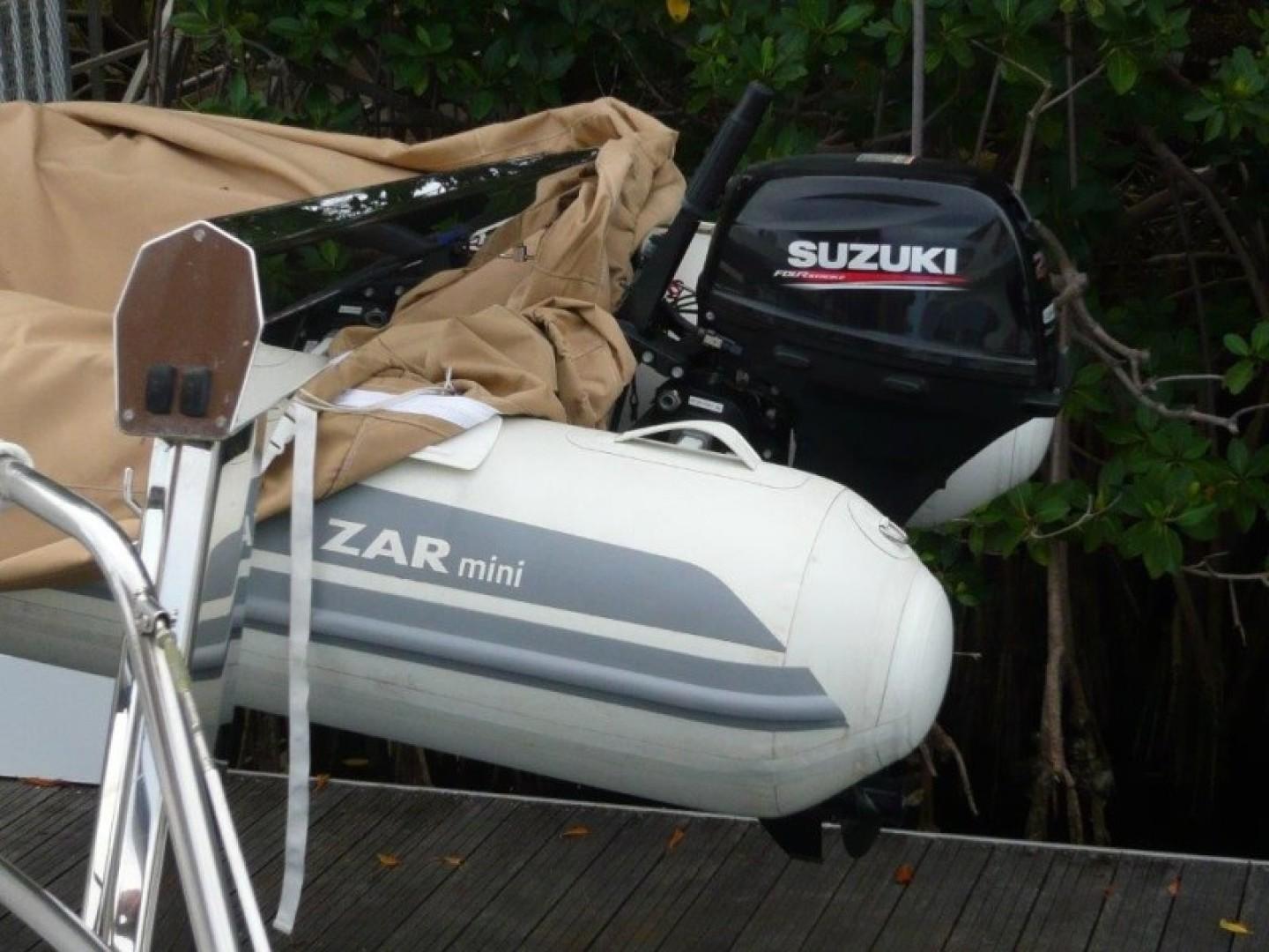 Inflatable Zar Mini boat with Suzuki outboard motor, docked near a Cheoy Lee Sloop, 1990 model.