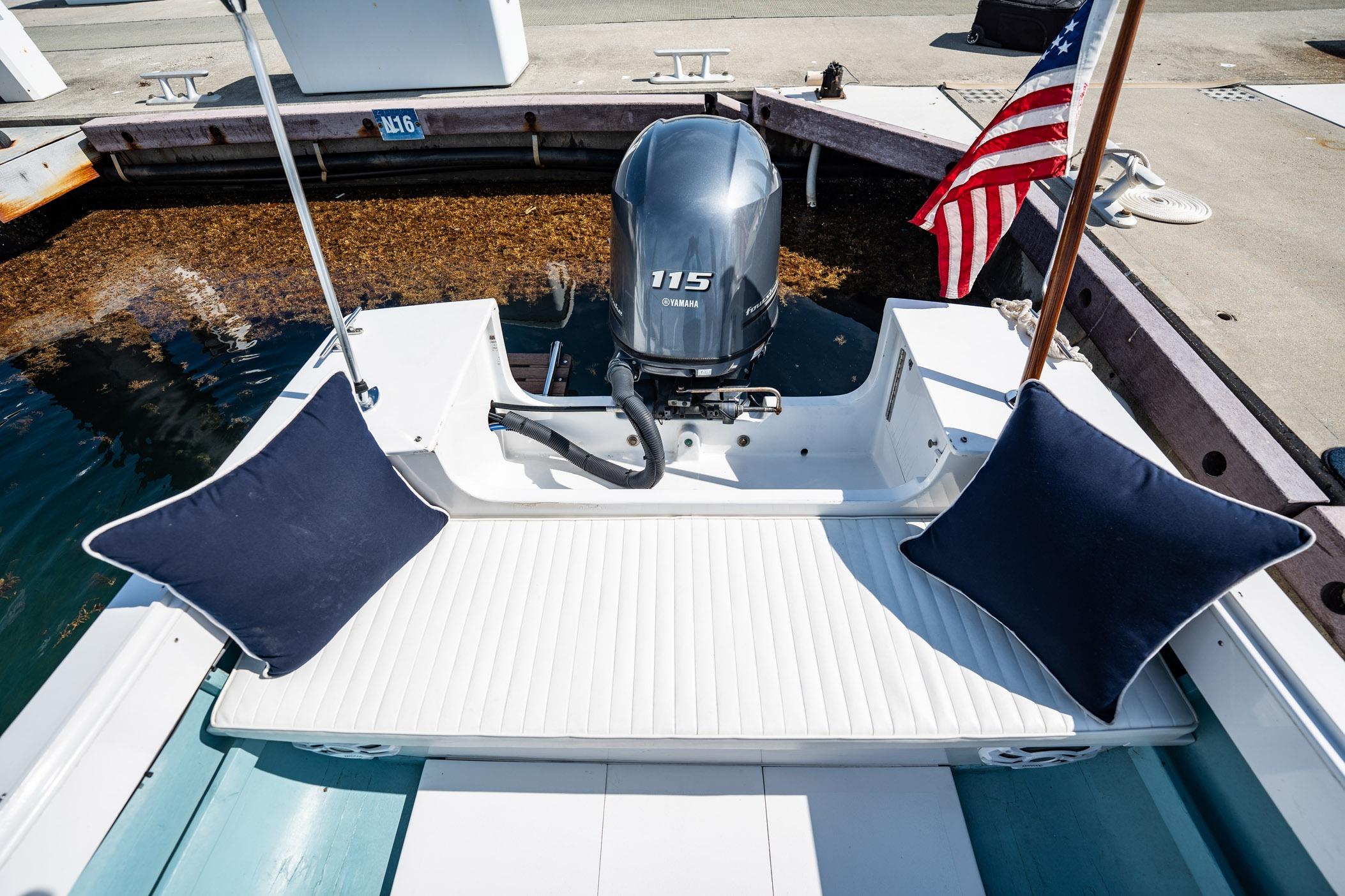 1982 Albury Brothers Runabout with Yamaha 115 engine, docked with cushions and American flag.