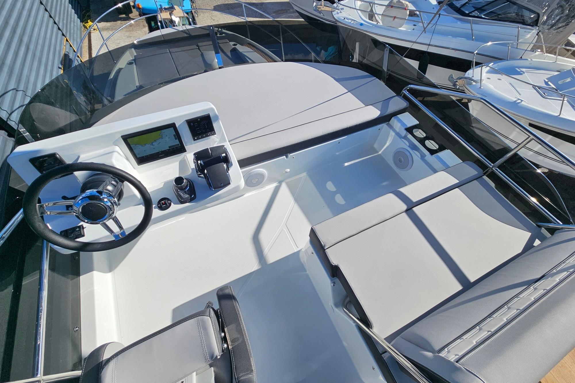 2026 Jeanneau Merry Fisher 1095 Fly Serie 2 helm station with modern controls and seating.