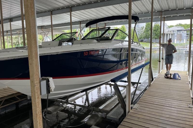 2022 Cobalt R4 boat docked in a covered marina with a person standing nearby.