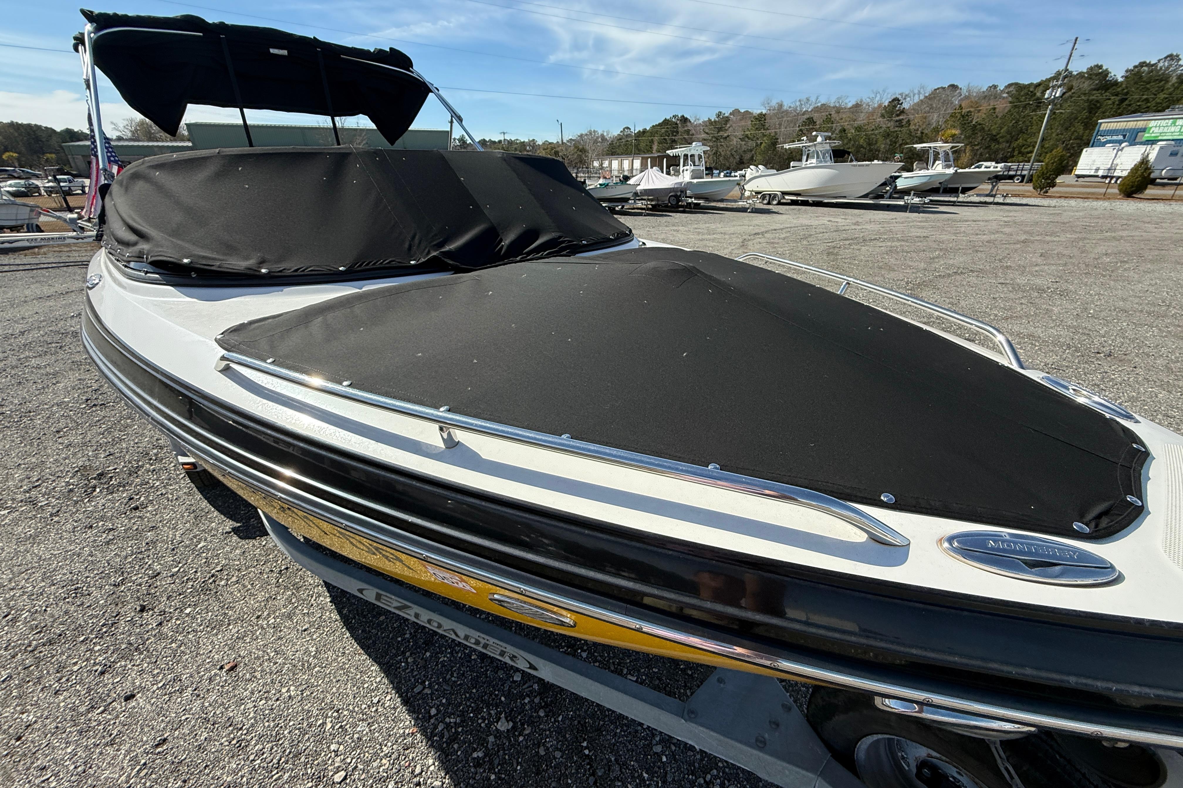 2014 Monterey 197 Blackfin boat with black cover in a marina setting.