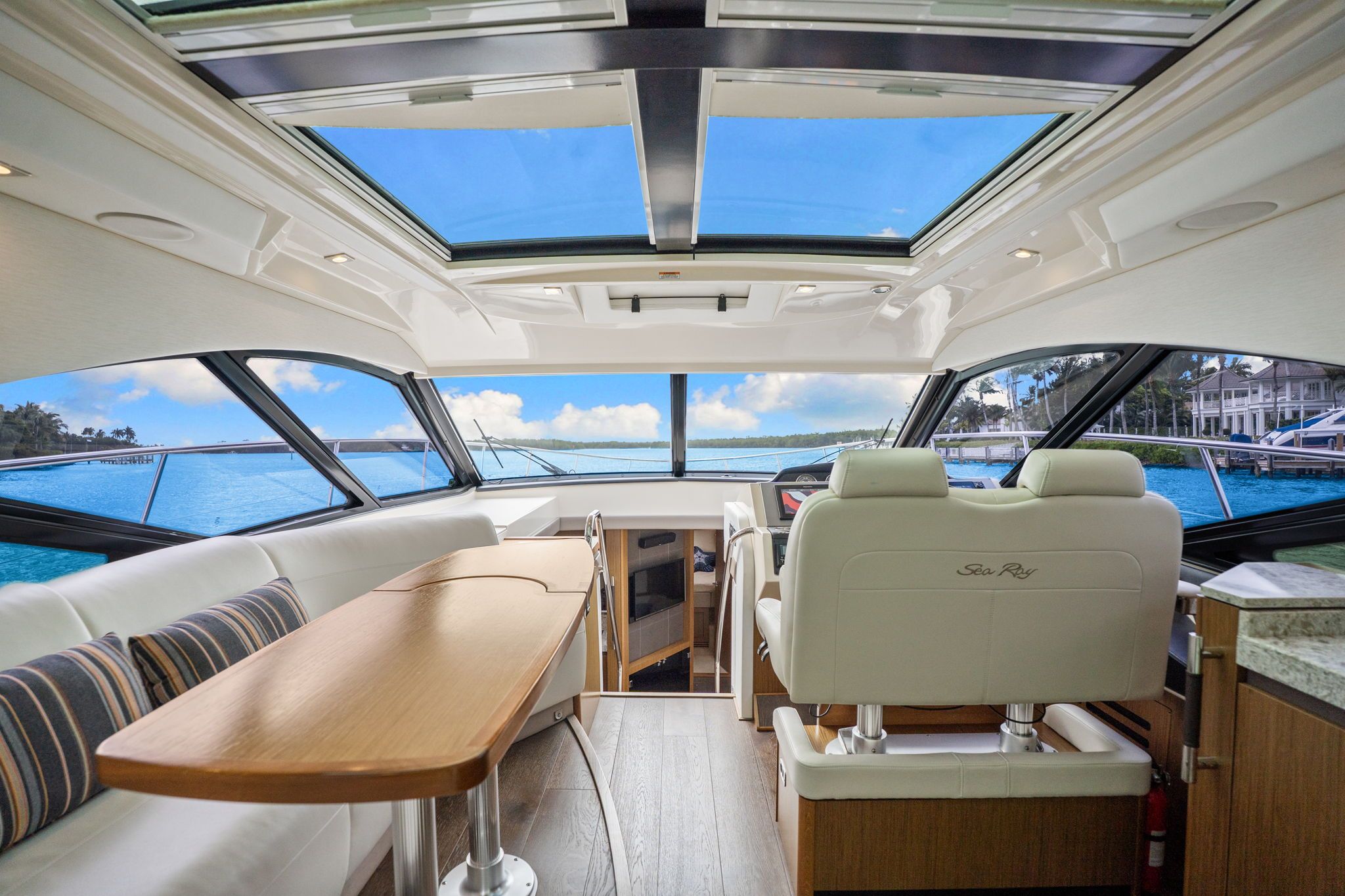 Interior of a Sea Ray Sundancer 510 with panoramic windows and modern cockpit.
