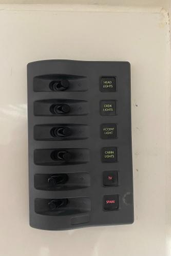Switch panel with six toggle switches for various boat functions.