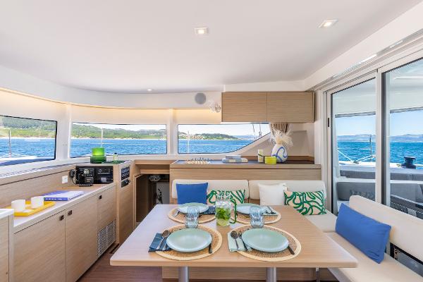 Modern interior of 2025 Lagoon 43 yacht with dining area and ocean view.